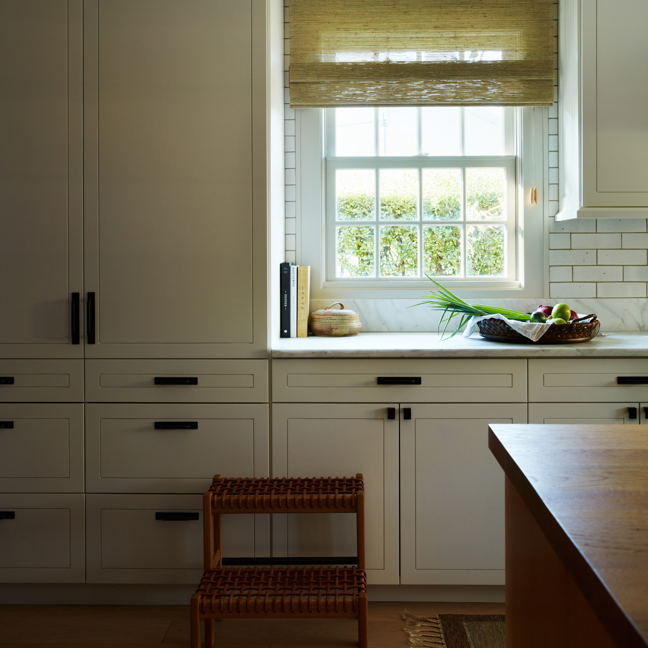 a kitchen with white cabinets and a window