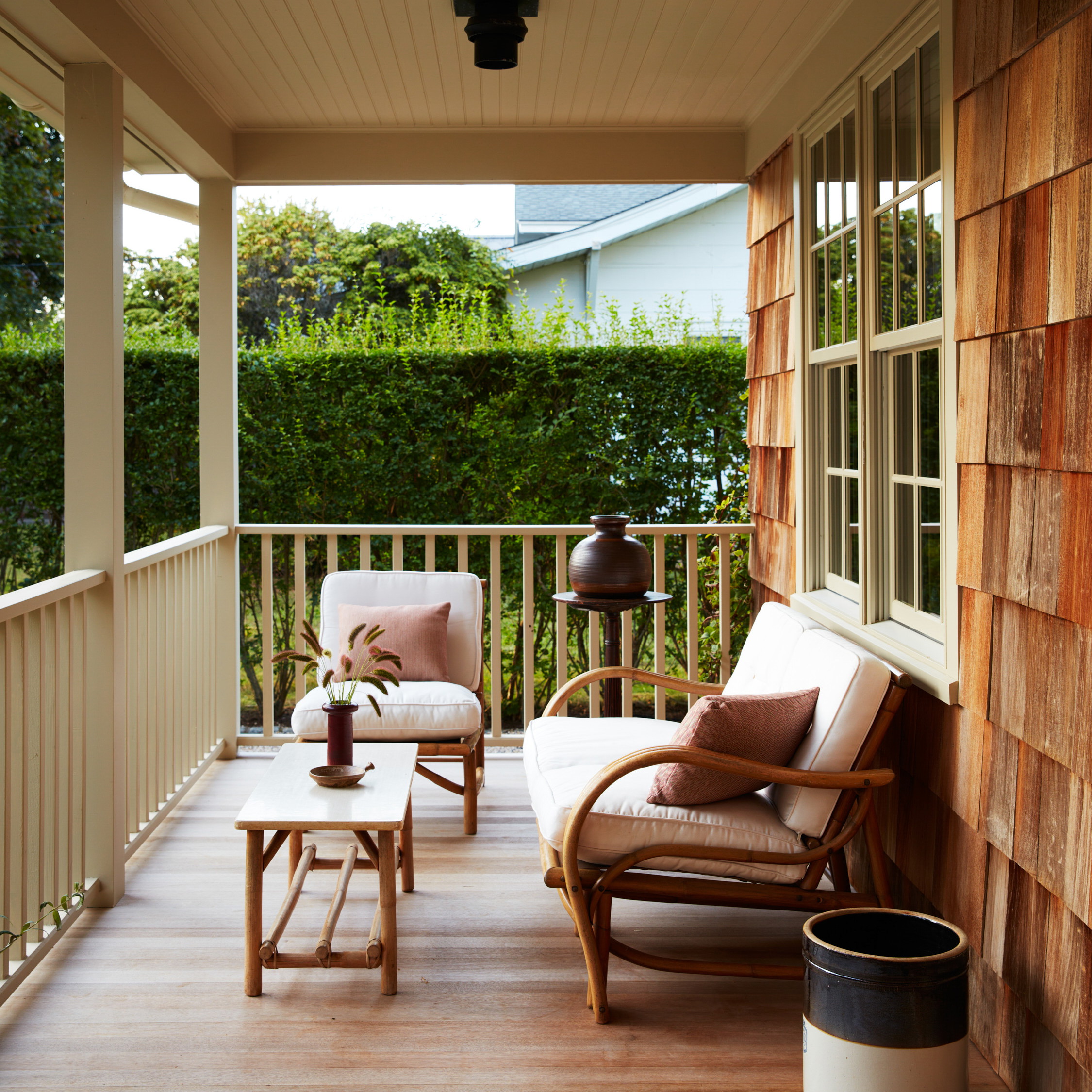 a porch with two chairs and a table on it