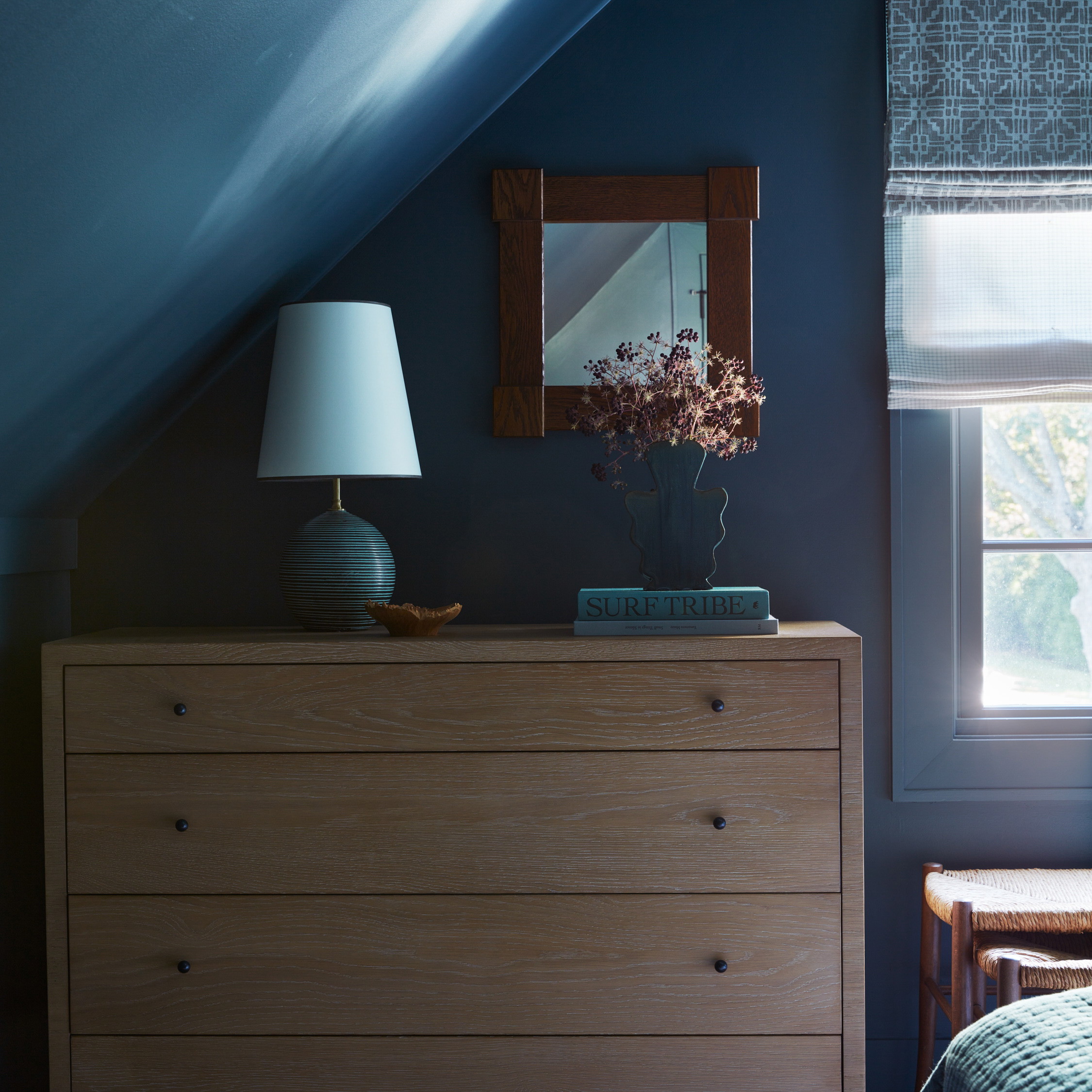 a bedroom with blue walls and a dresser