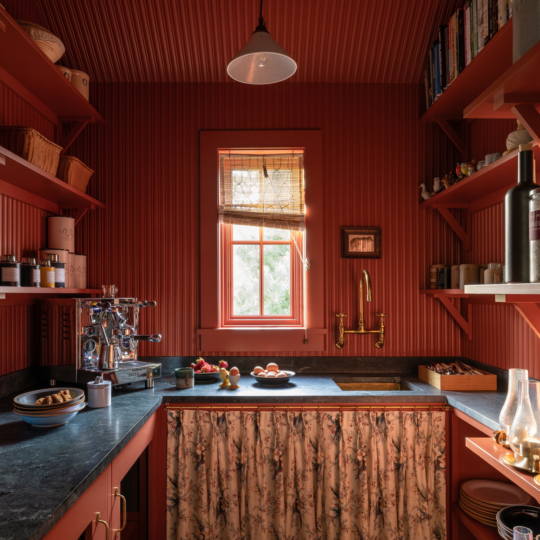 a kitchen with red walls and a black counter top