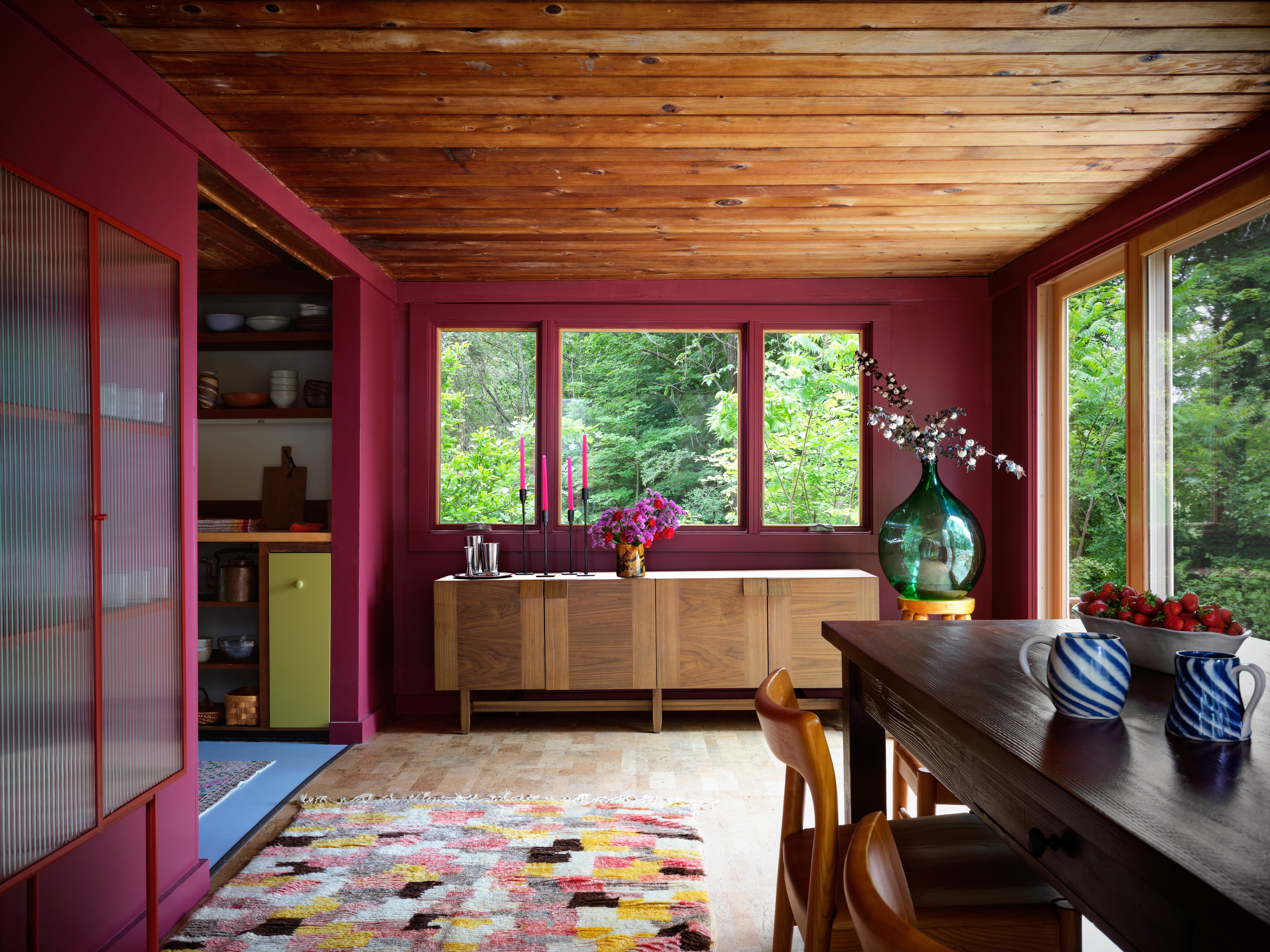 a dining room with a table and a vase of flowers