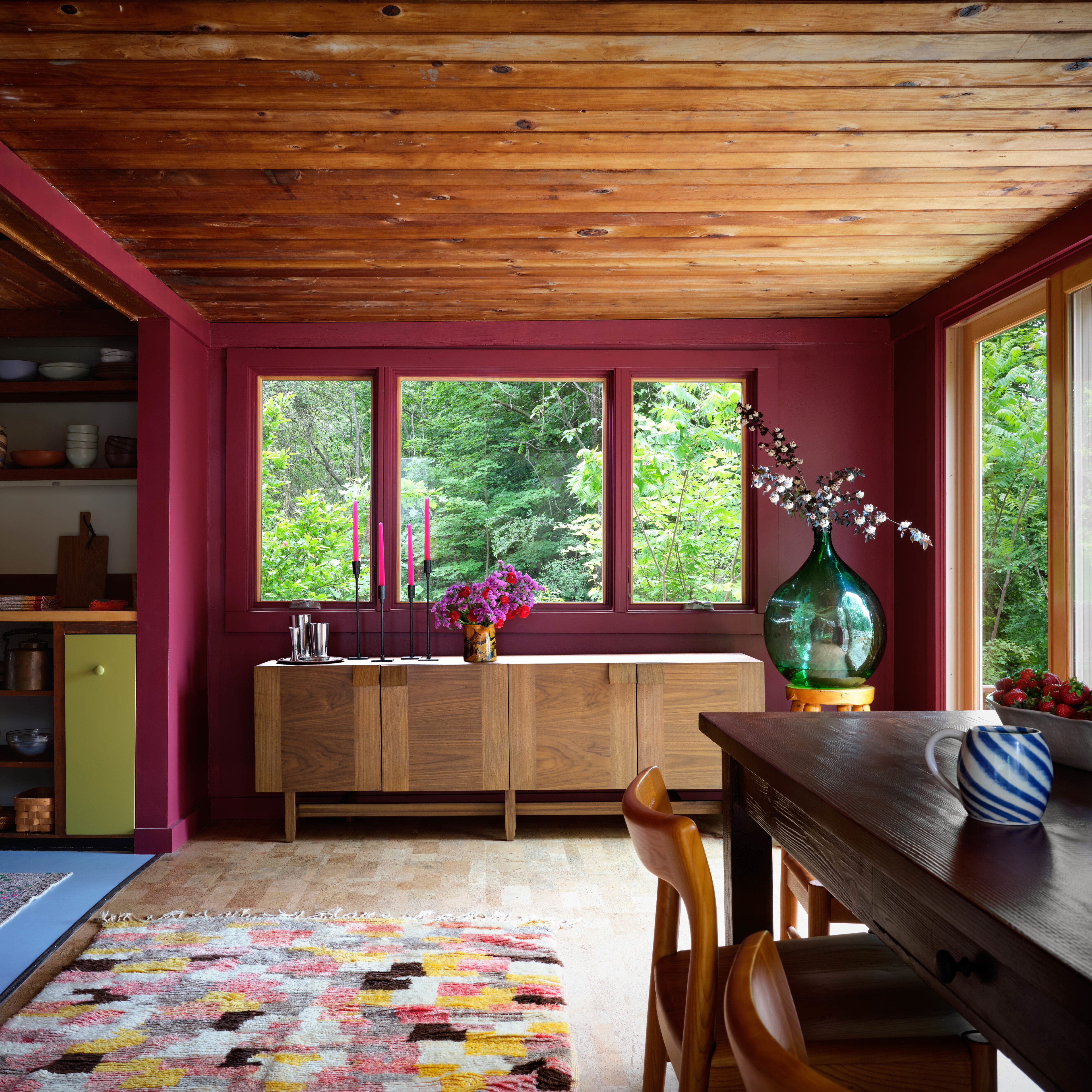 a dining room with a table and a vase of flowers
