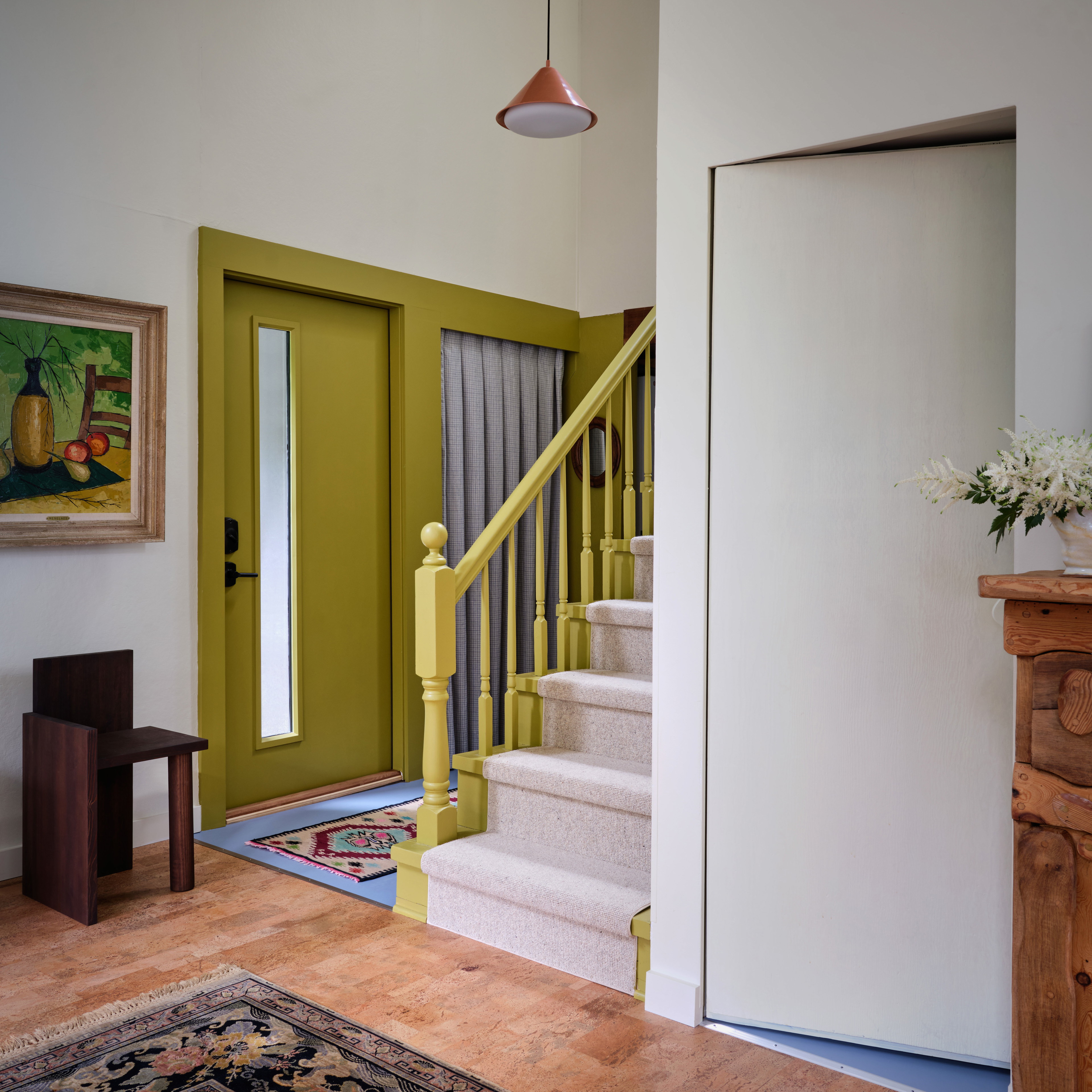 a room with a green door and stairs