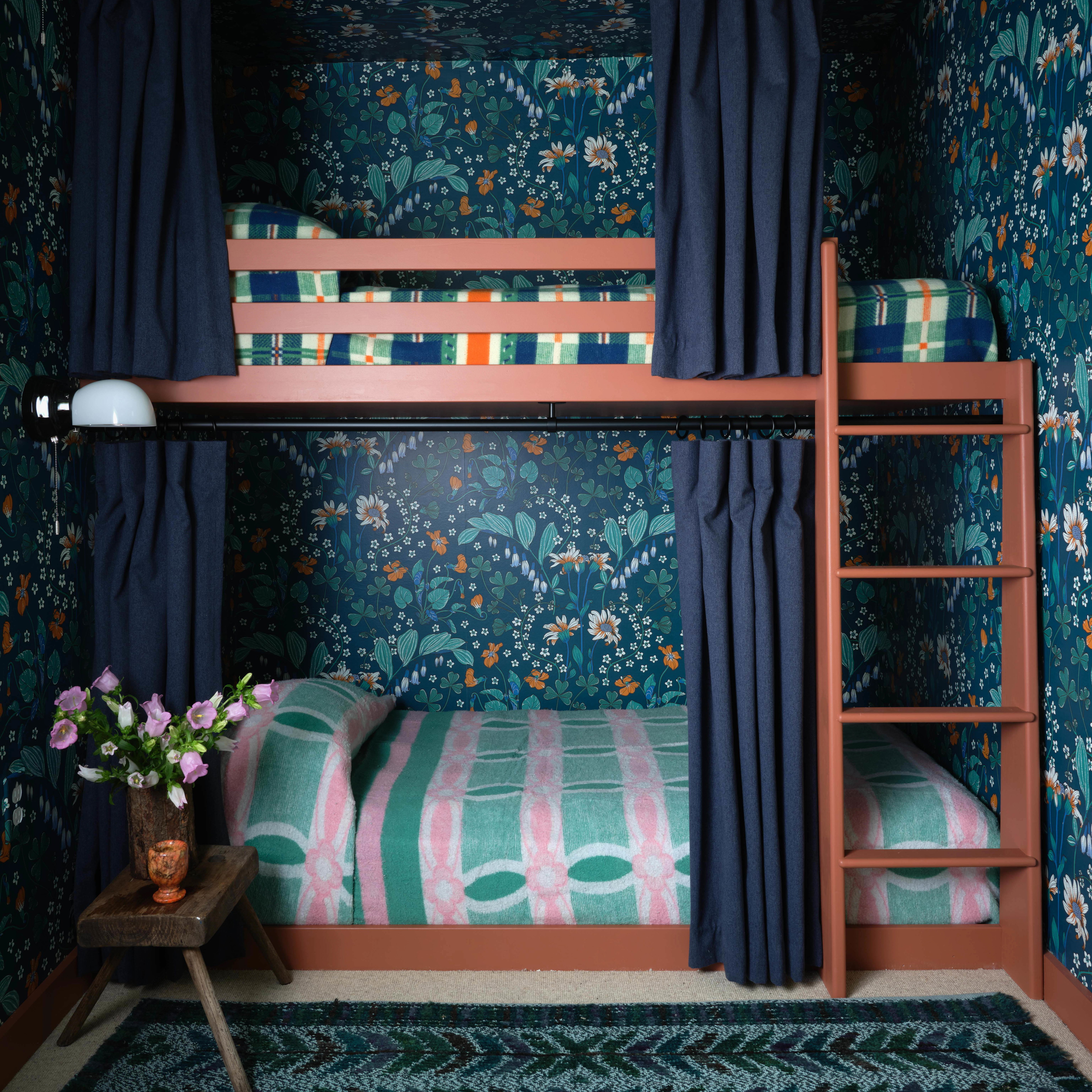 a bedroom with a bunk bed and floral wallpaper