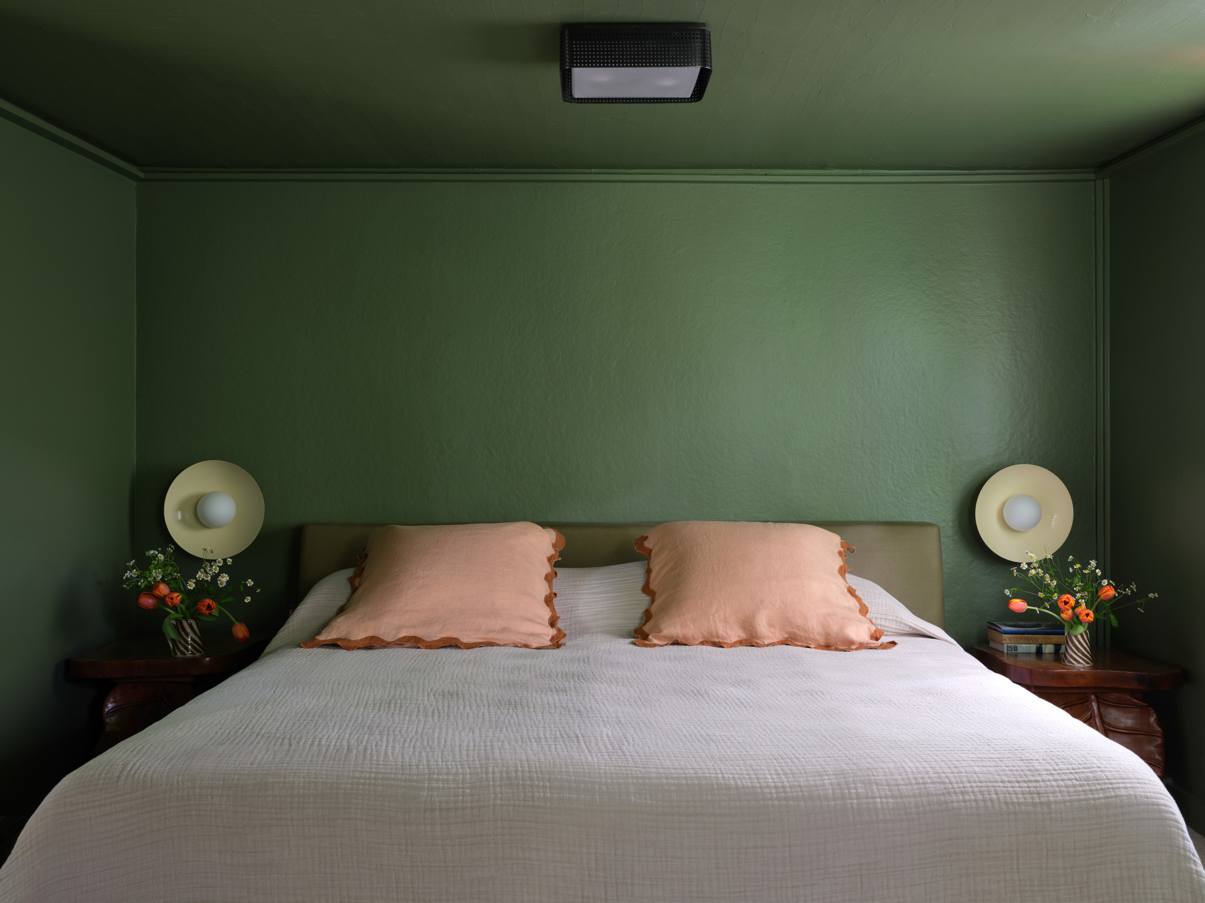 a bed with two pillows and two lamps