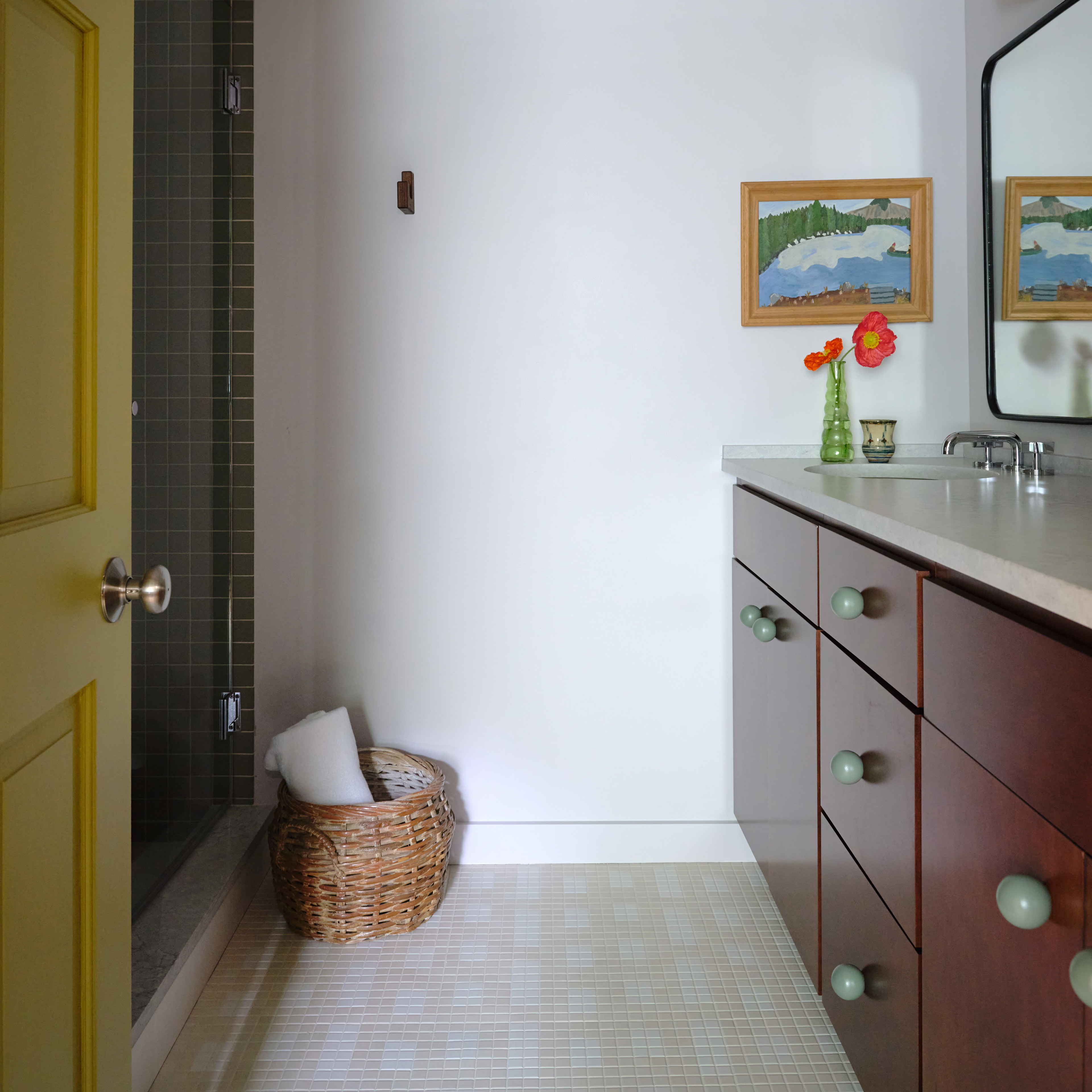 a bathroom with a sink, mirror, and a basket