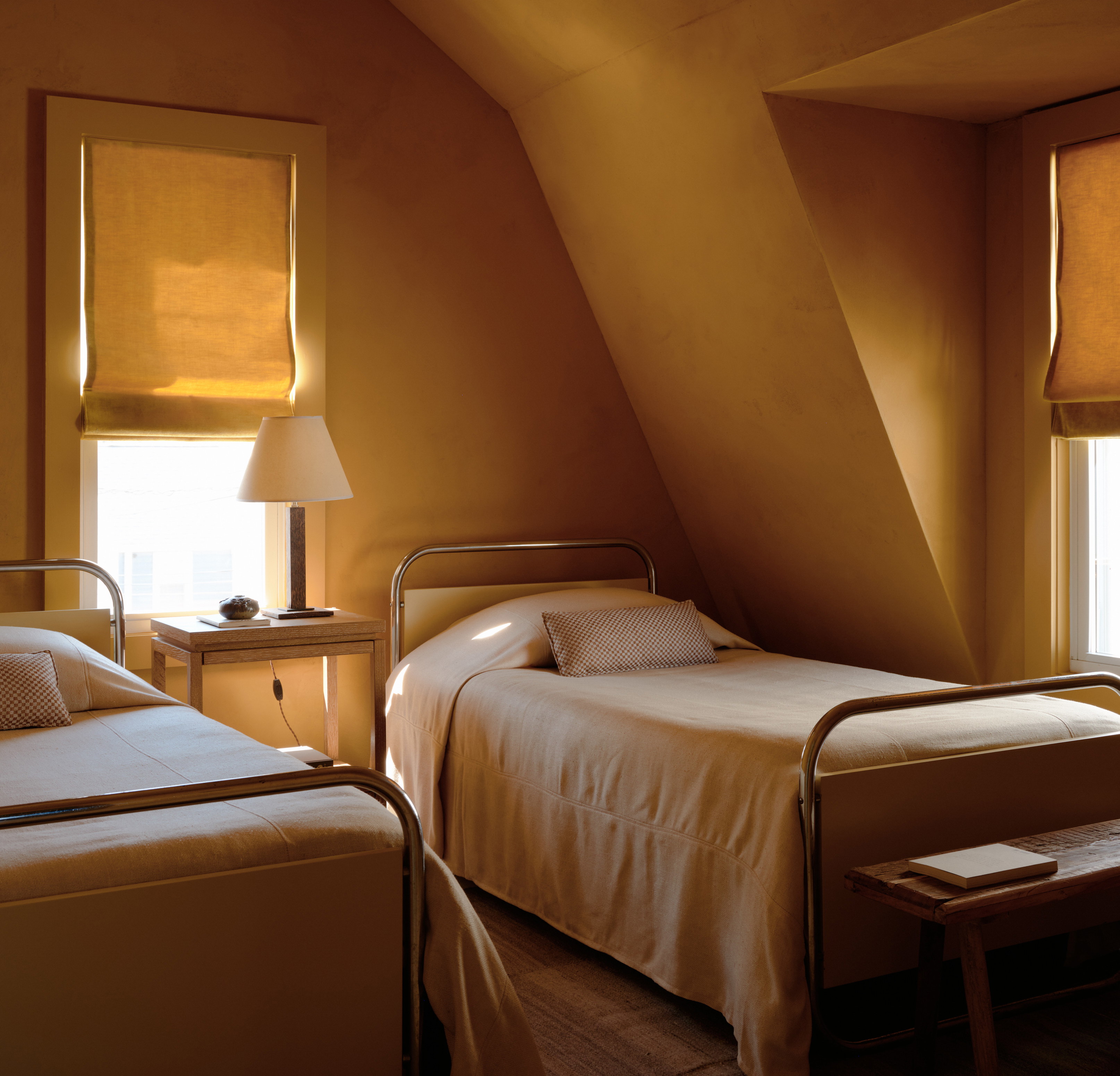 a bedroom with two beds and two windows