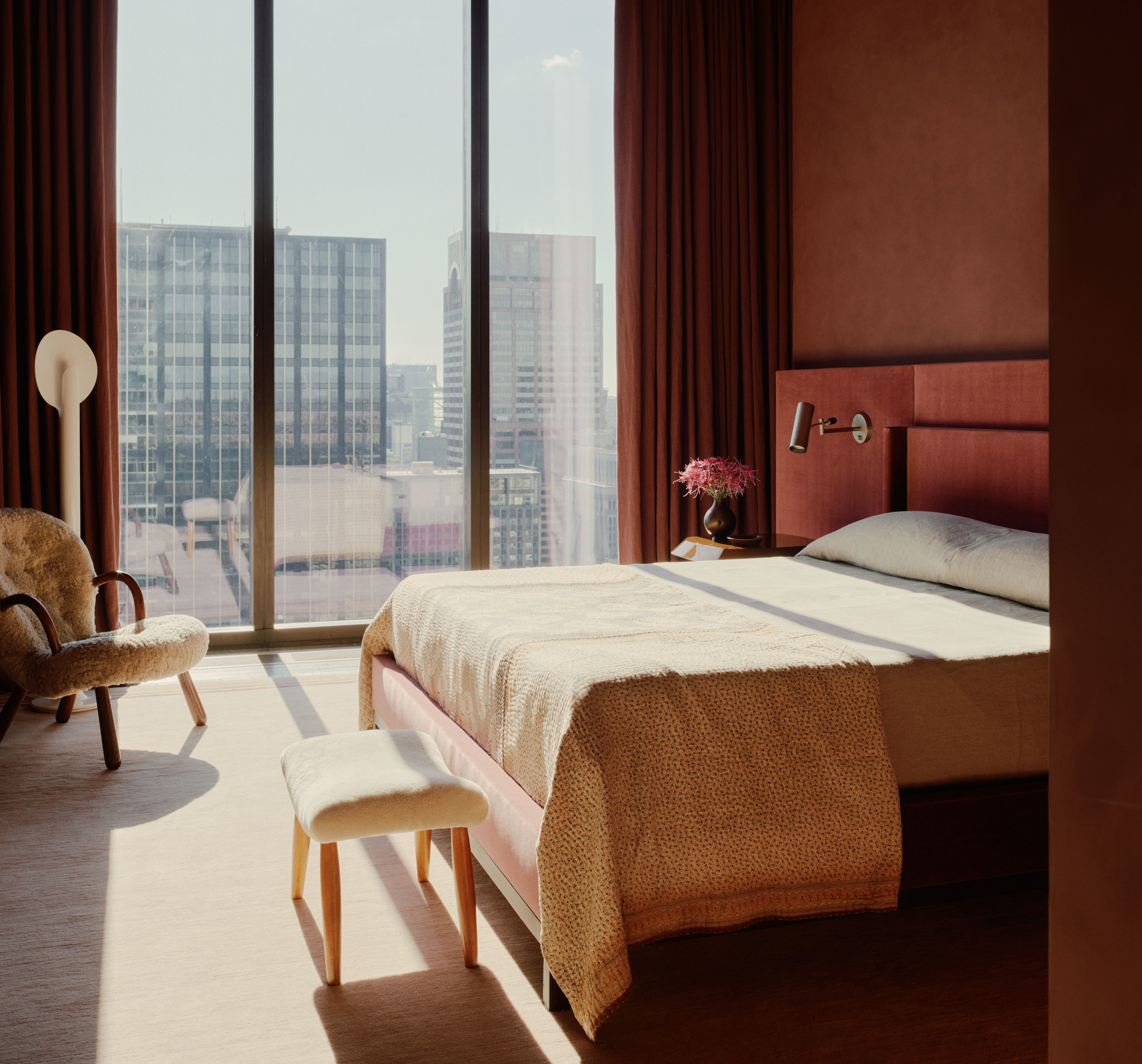 a bedroom with a large window overlooking a city