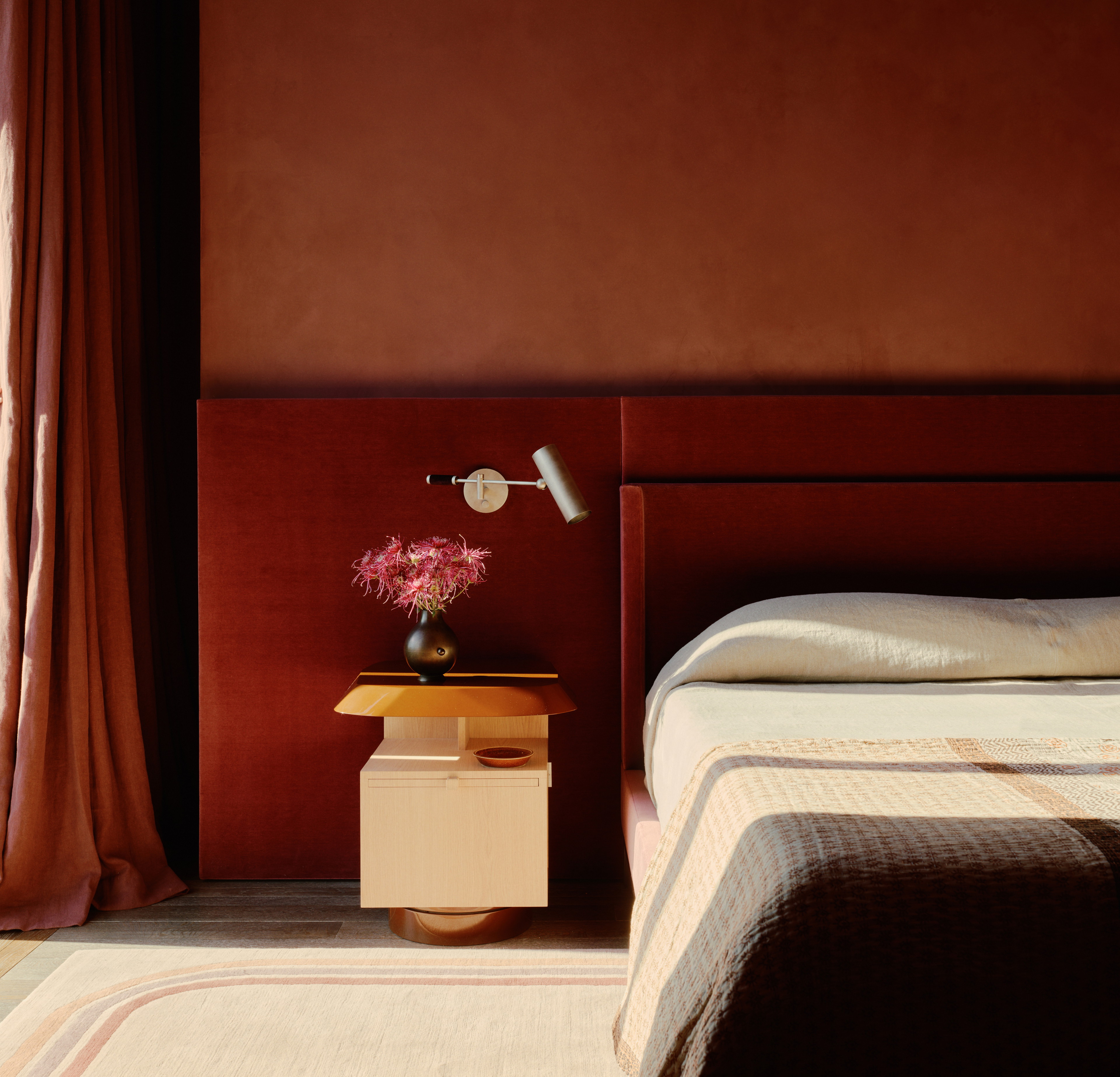 a bedroom with a bed, nightstand, and window