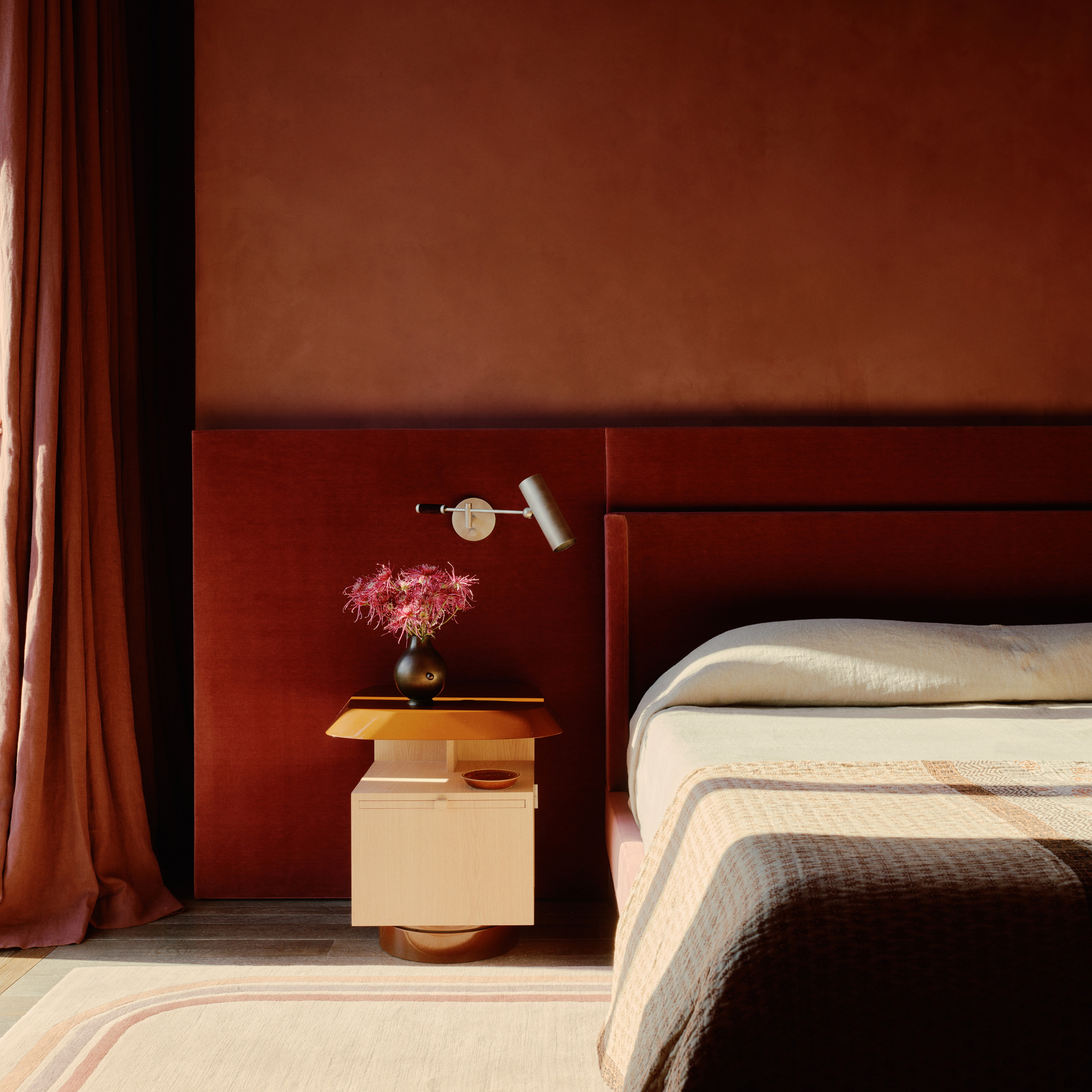 a bedroom with a bed, nightstand, and window