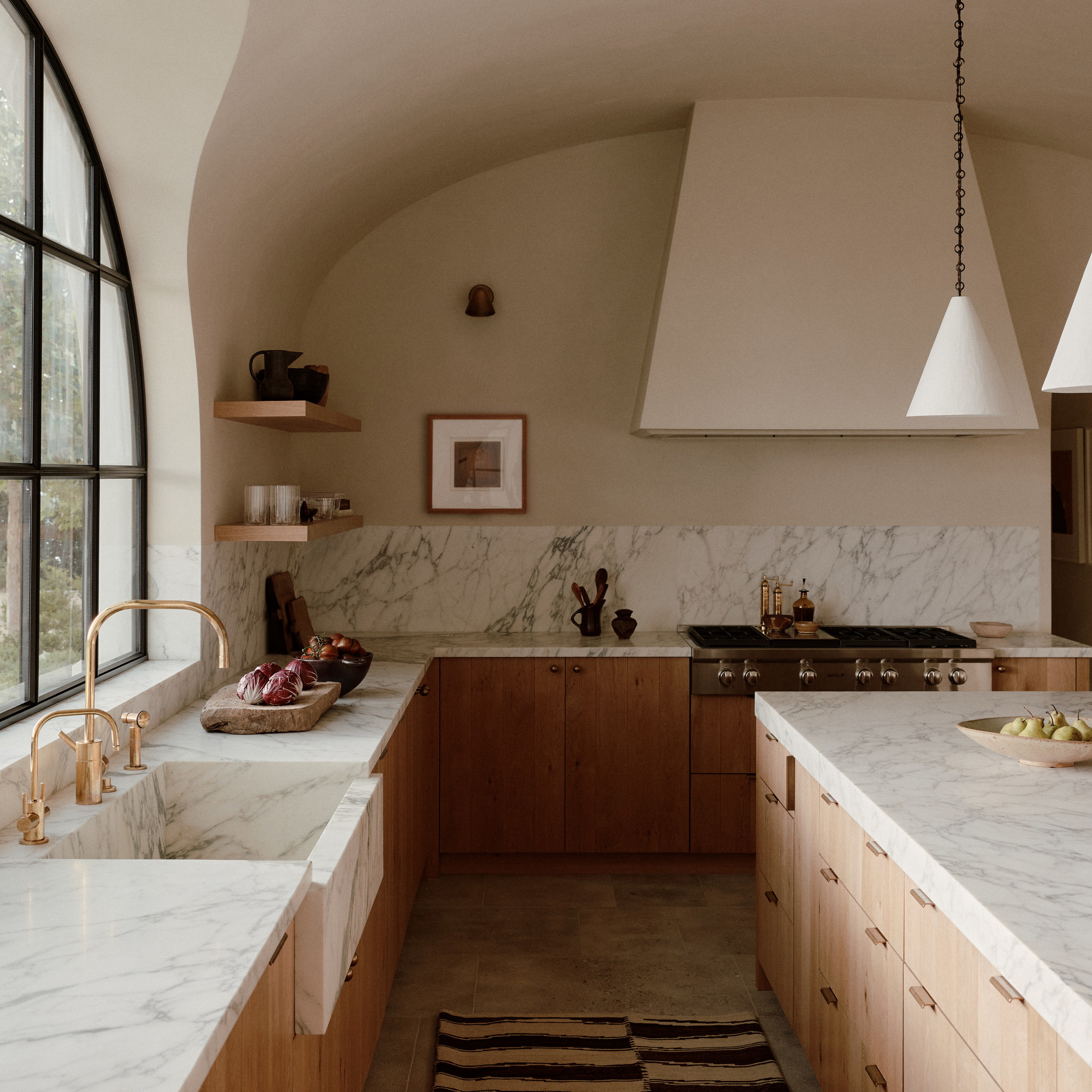 a kitchen with marble counter tops and wooden cabinets
