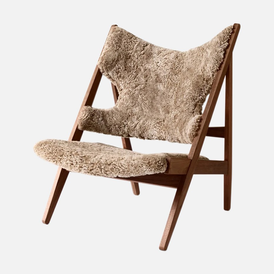 a wooden chair with a sheepskin seat cushion