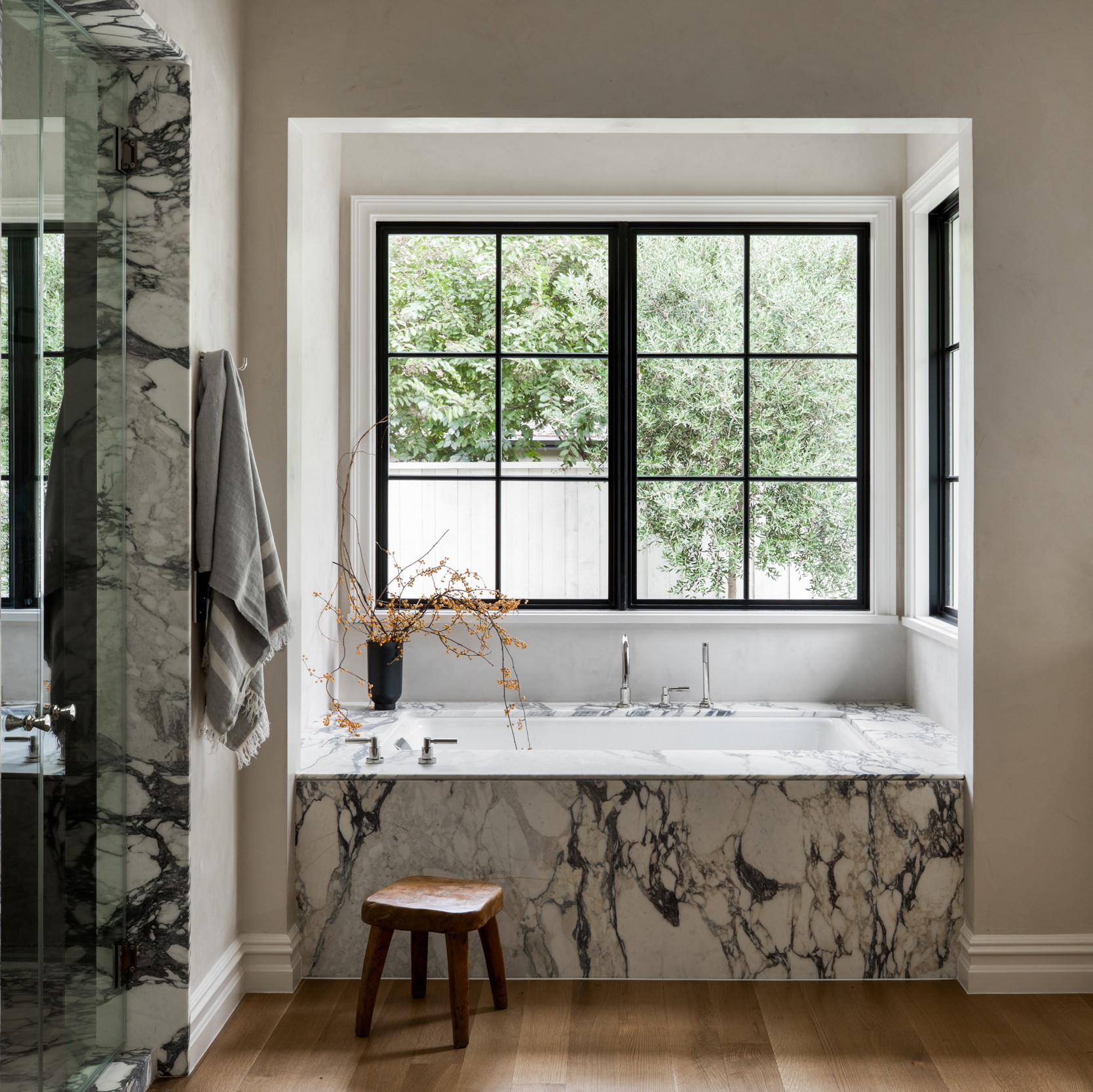 a bathroom with a large window and a marble bathtub