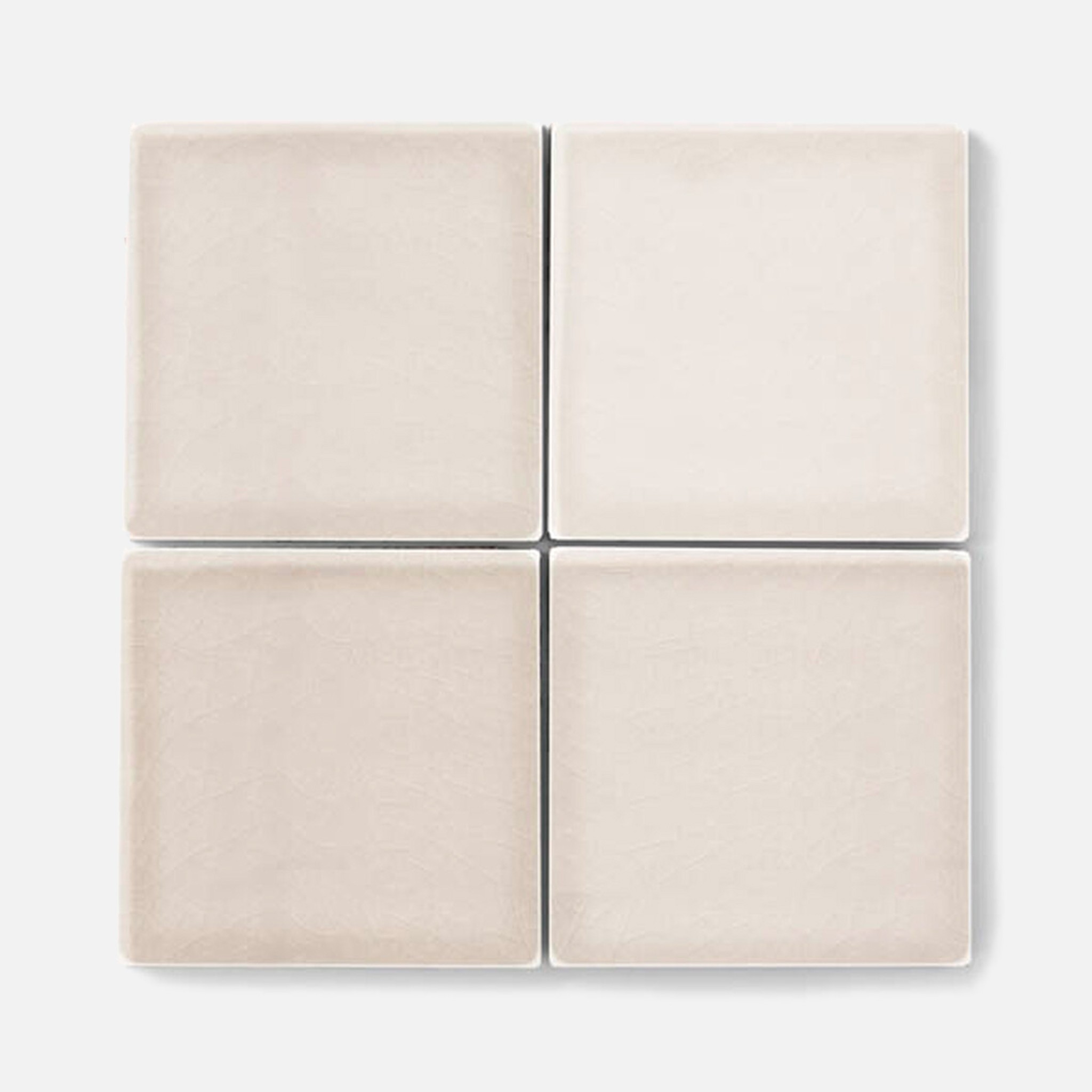 a white tile wall with four square tiles
