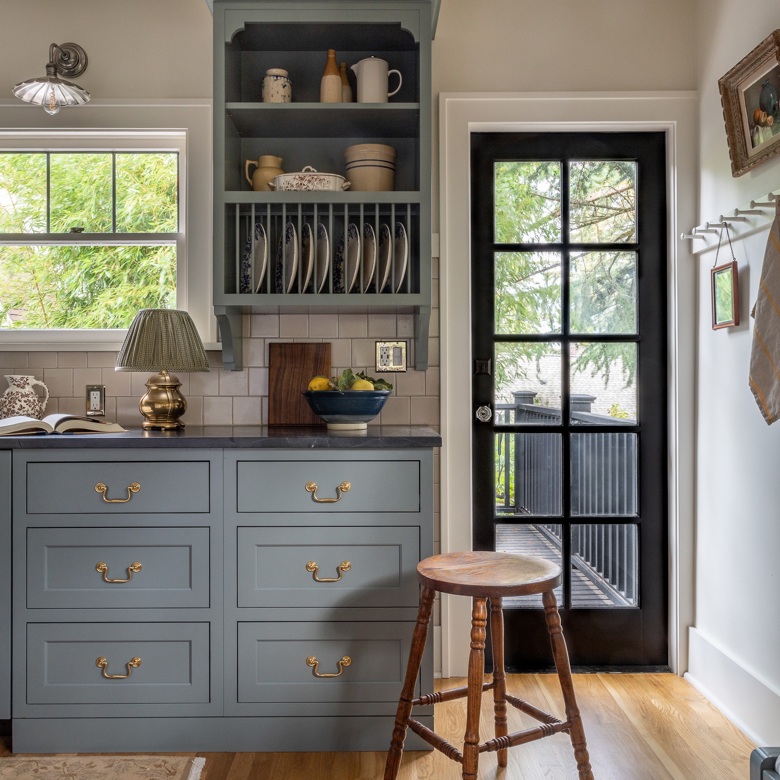 a kitchen with blue cabinets and a wooden stool