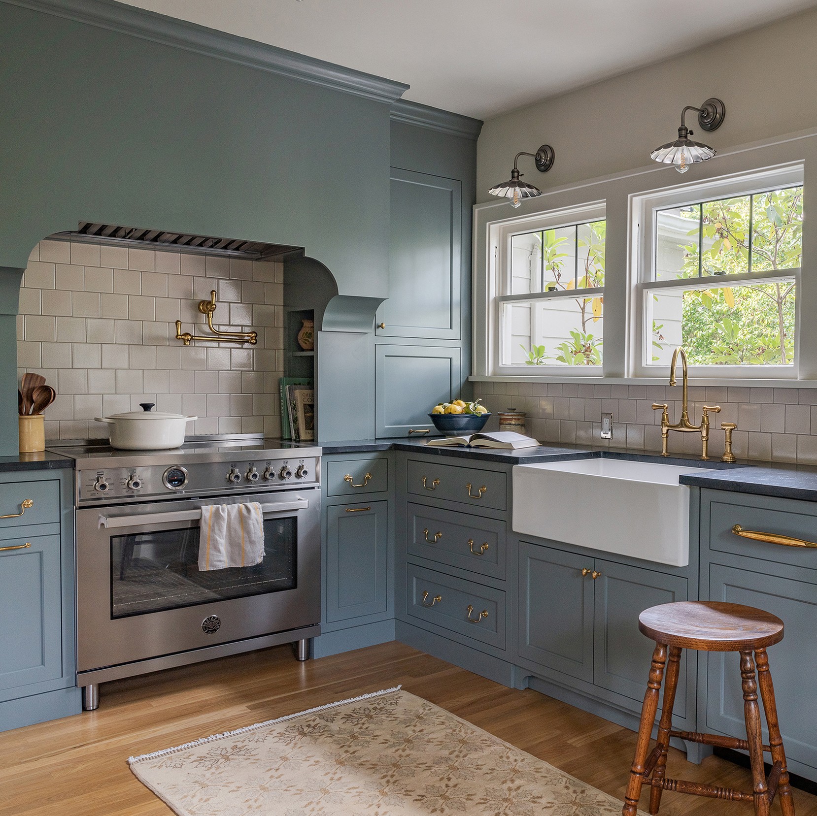 a kitchen with blue cabinets and a white rug
