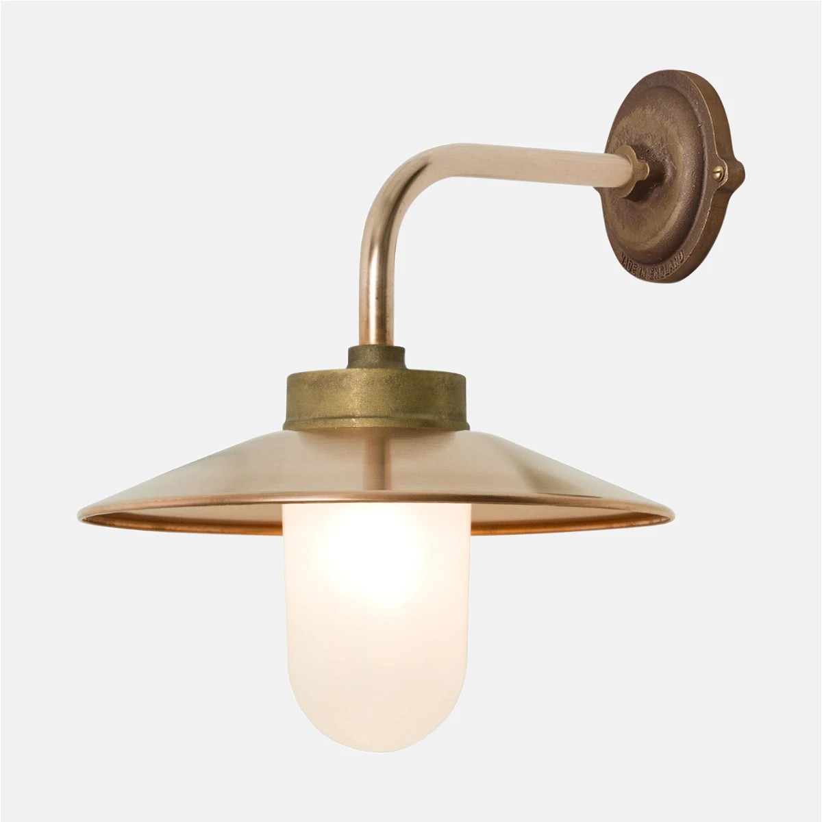 a brass wall light with a white glass shade