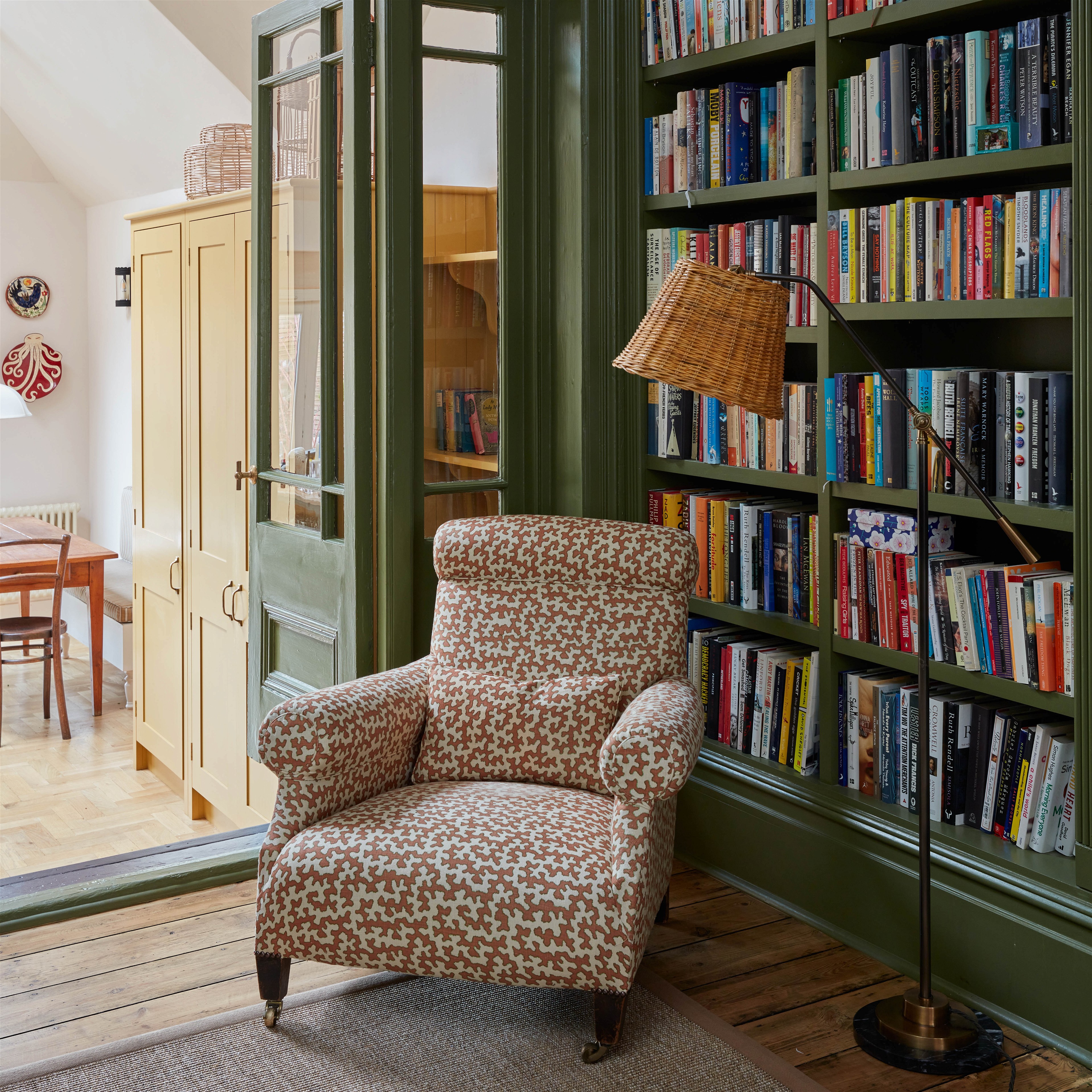 a living room with a chair and a book shelf