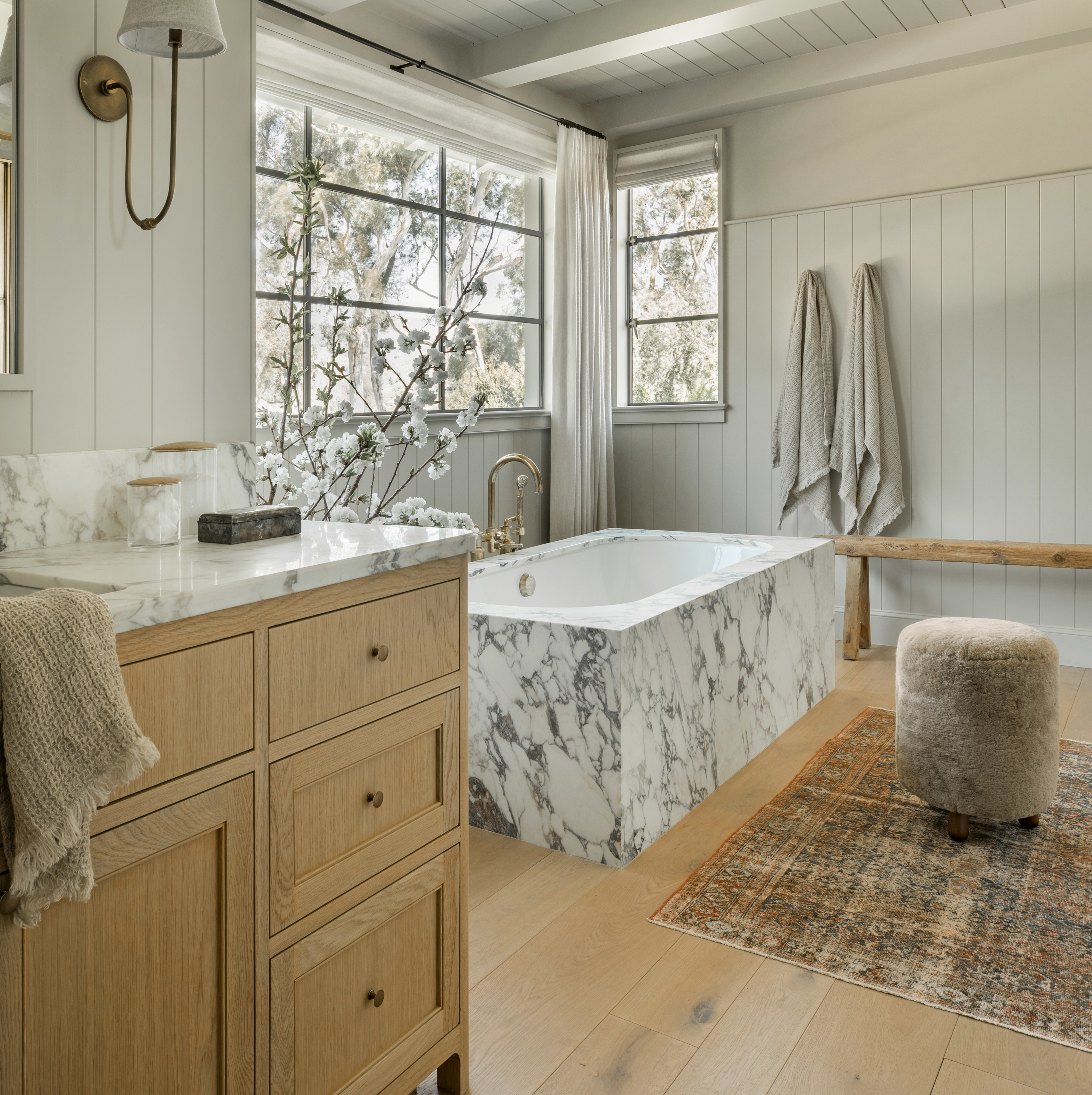 a bathroom with a large marble tub and wooden cabinets