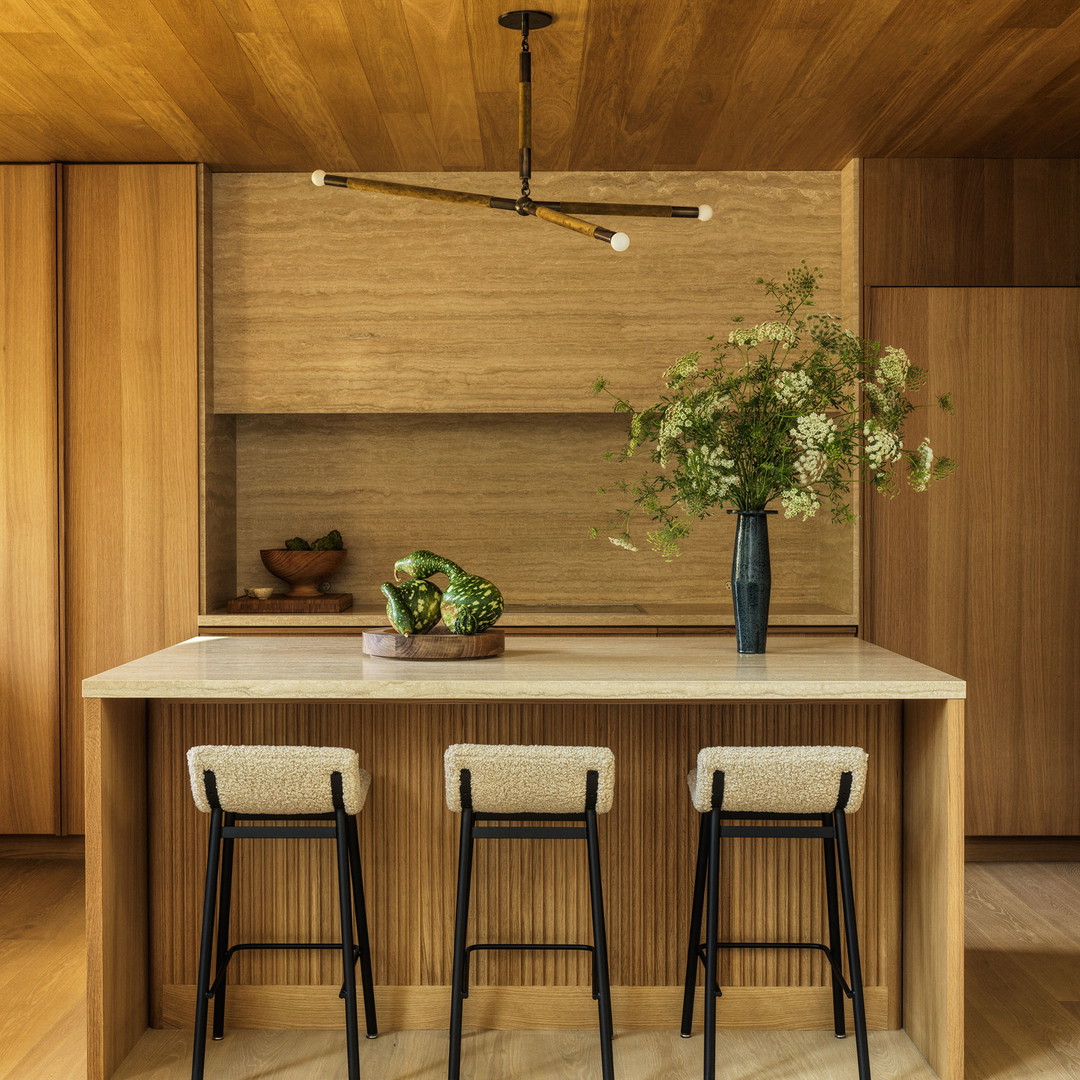 a kitchen with two stools and a center island
