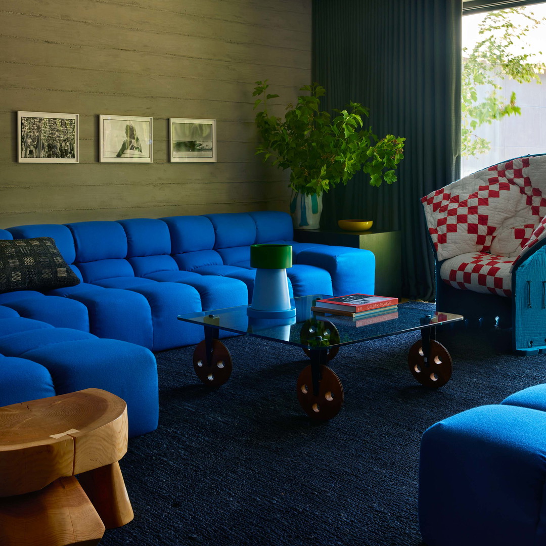 a living room filled with blue couches and a large window