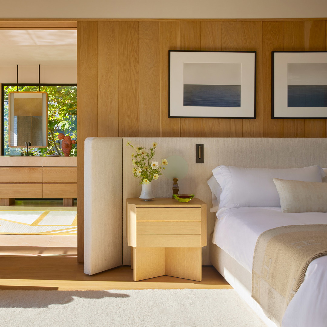 a bed room with a neatly made bed and pictures on the wall