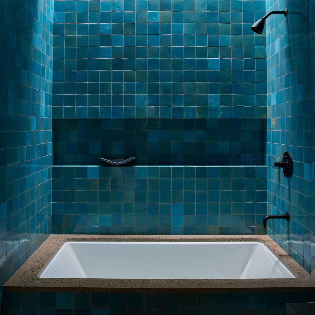 a bath tub sitting under a window in a bathroom