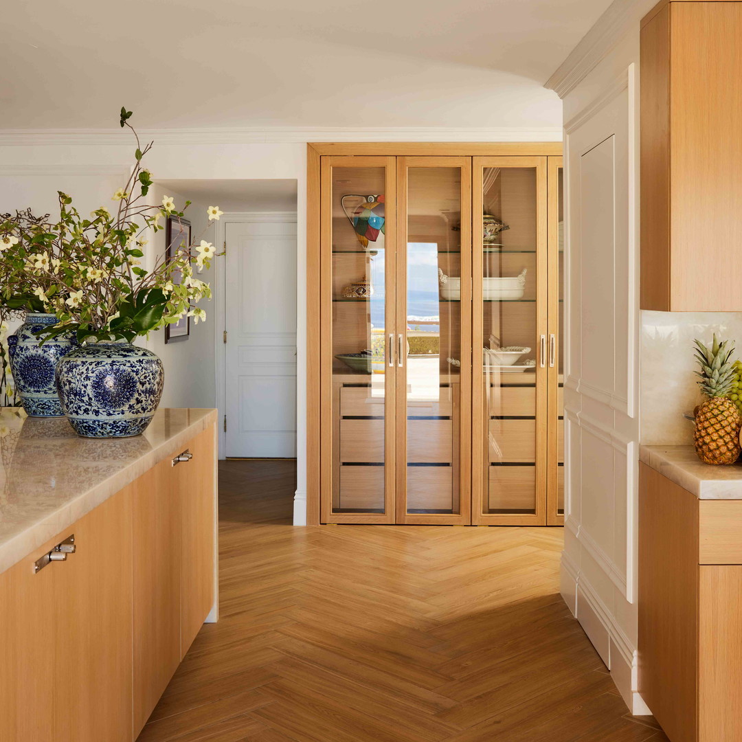 a kitchen with a wooden floor and a vase of flowers on the counter