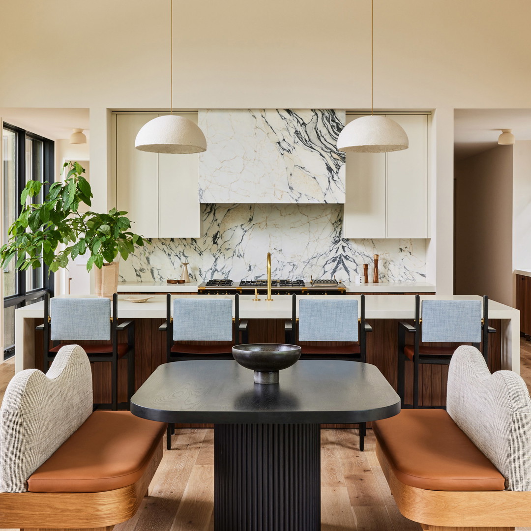 a kitchen with a table, chairs, cabinets and a potted plant