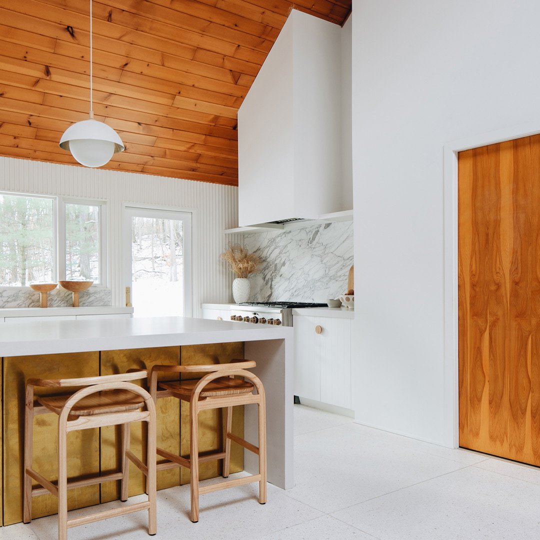 a kitchen with two stools in front of a counter