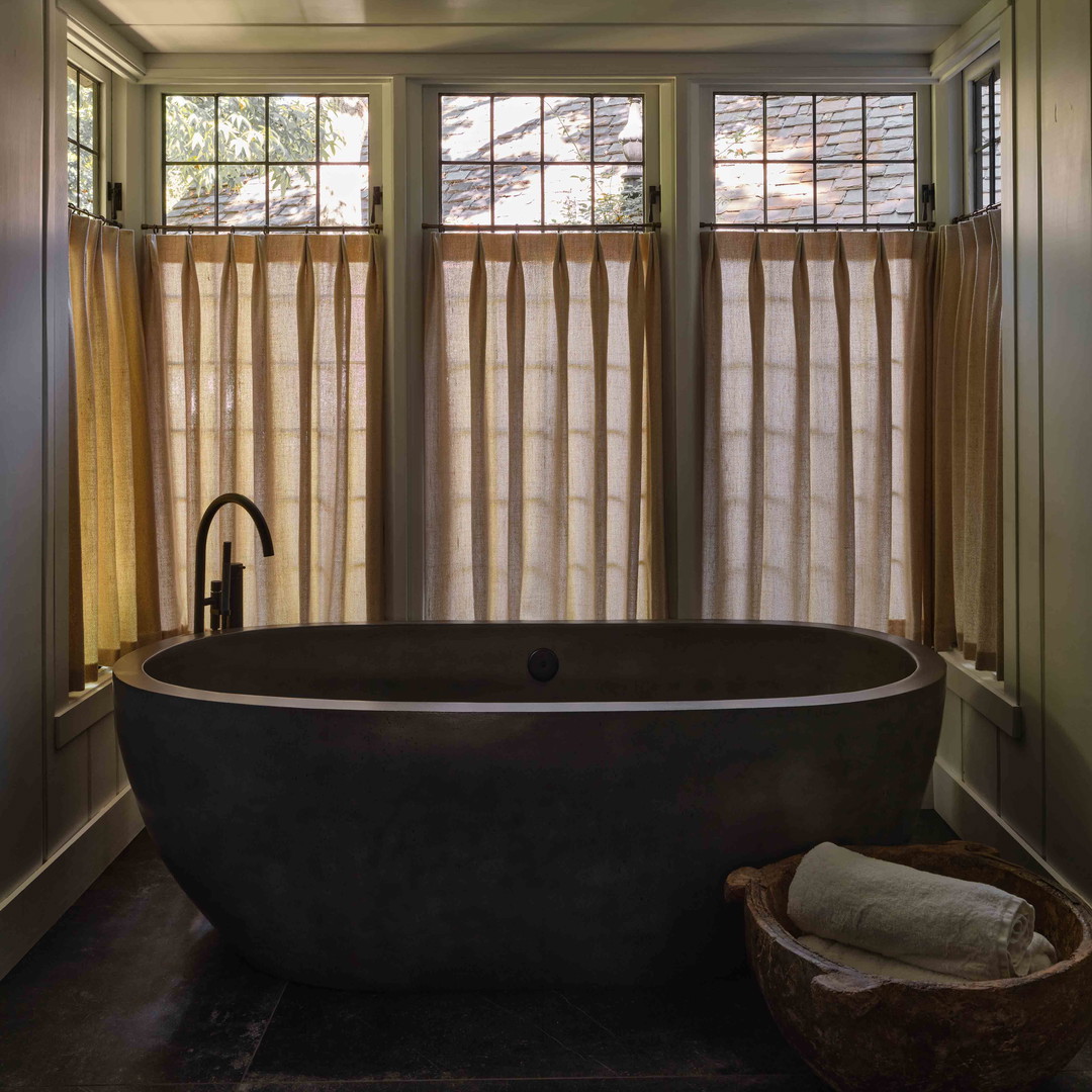 a bathroom with a large bathtub next to a window