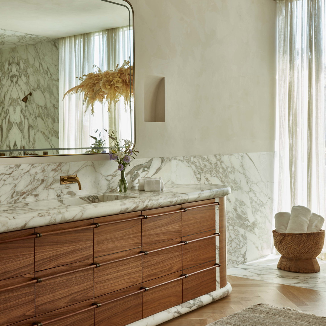 a bathroom with a marble counter top and wooden cabinets