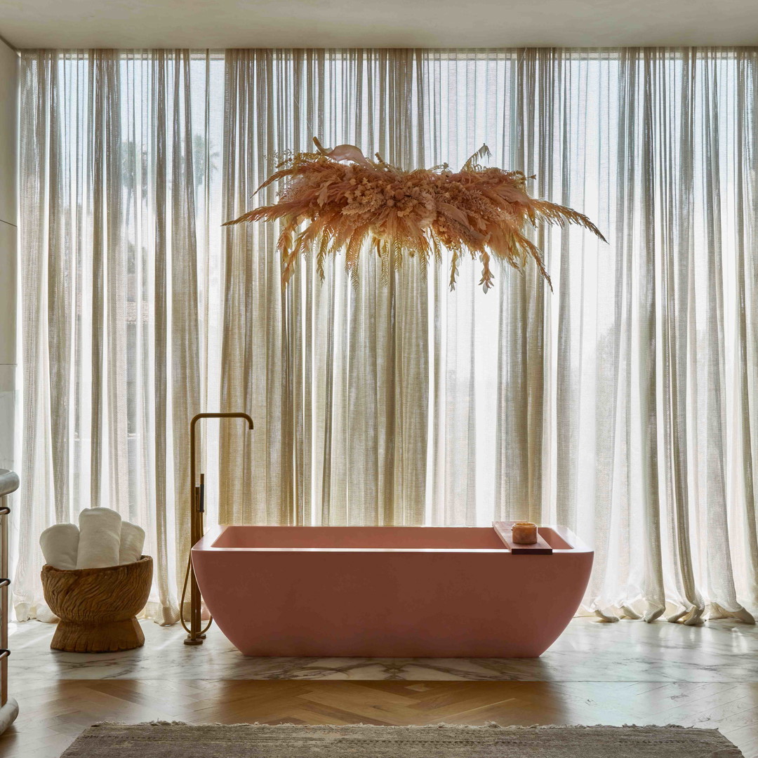 a bathroom with a pink bathtub and a large window