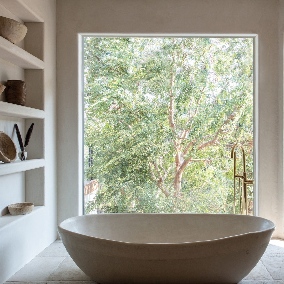 a large white bath tub sitting in a bathroom next to a window