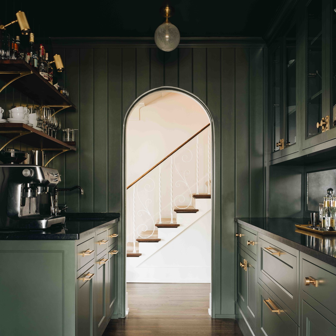 a kitchen with green cabinets and a rug on the floor