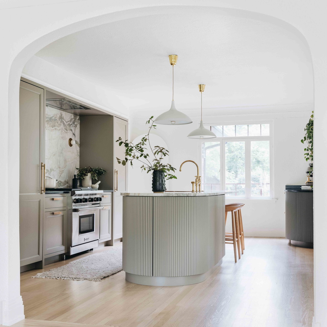 a kitchen with a stove, sink, oven and a dining room table