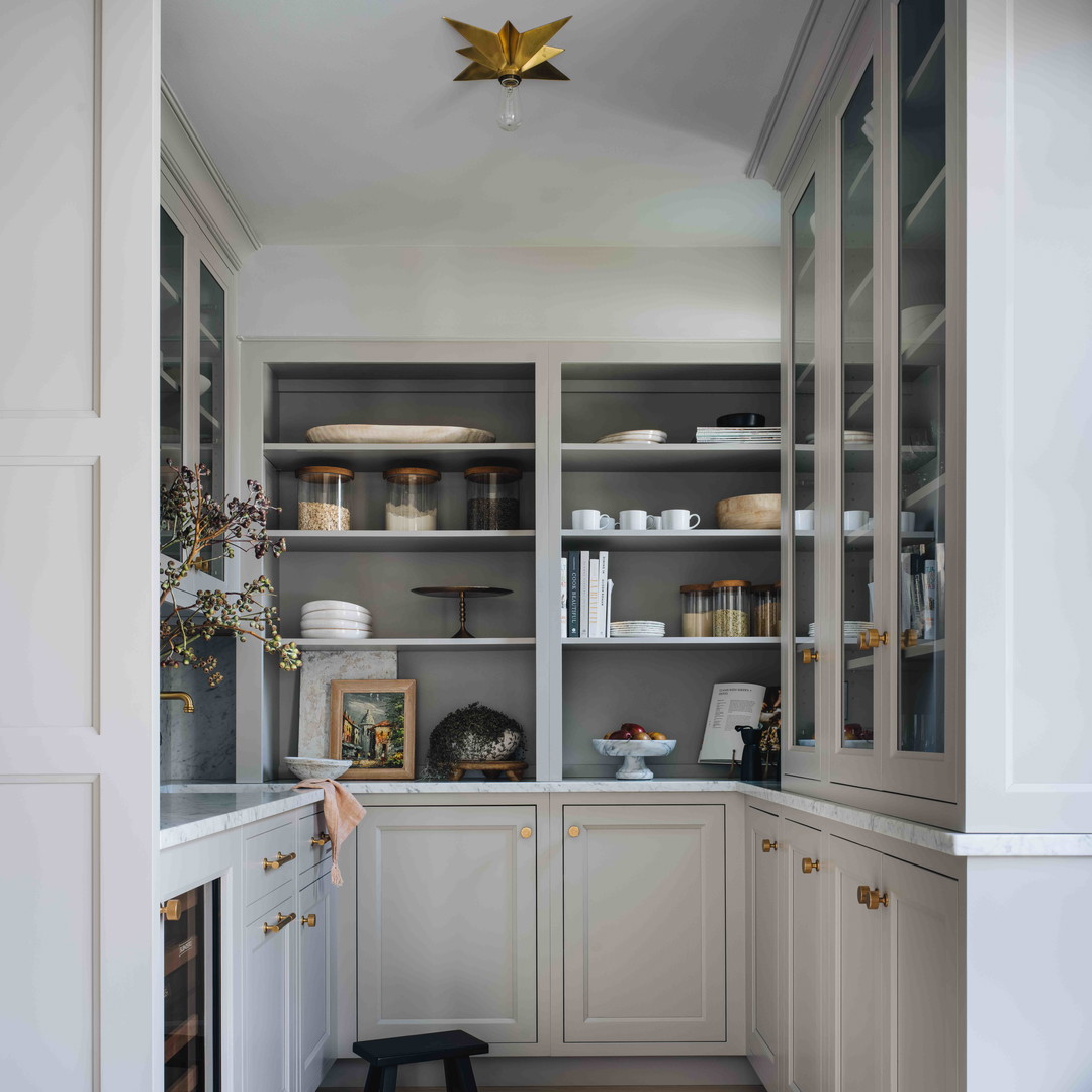 a kitchen with white cabinets and wooden floors