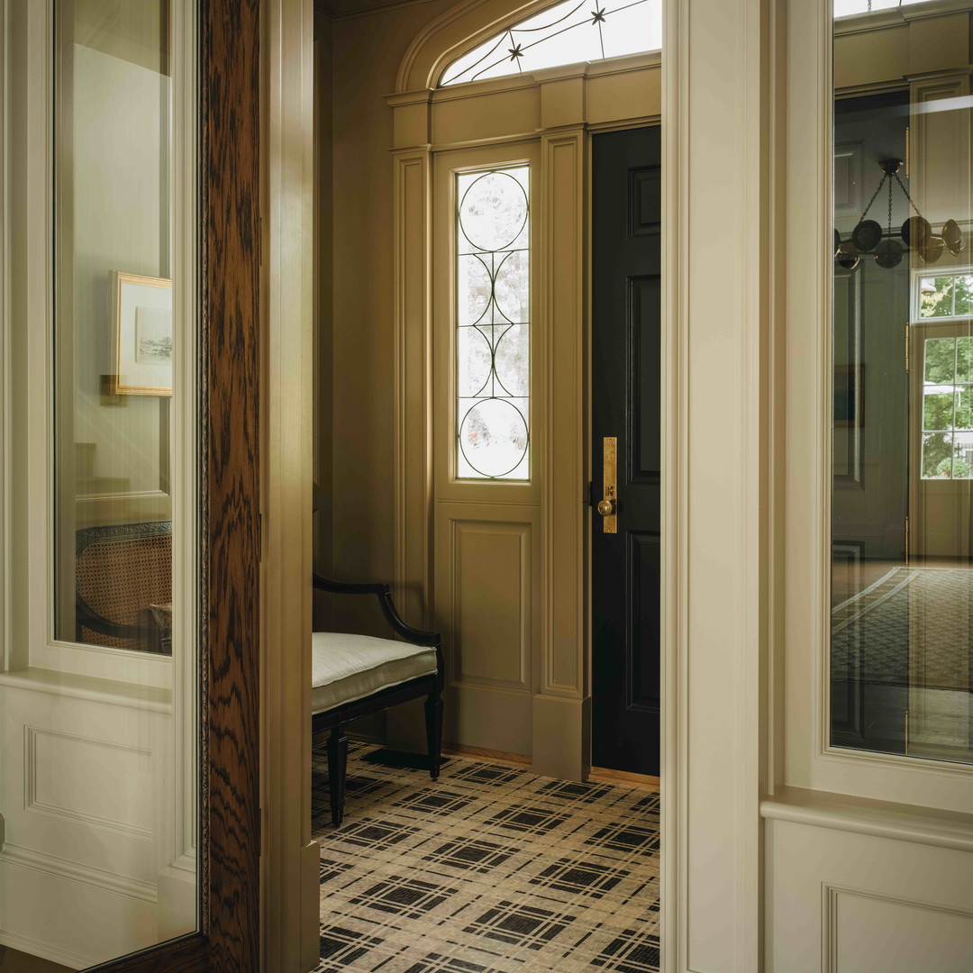 a hallway with a bench and a chandelier