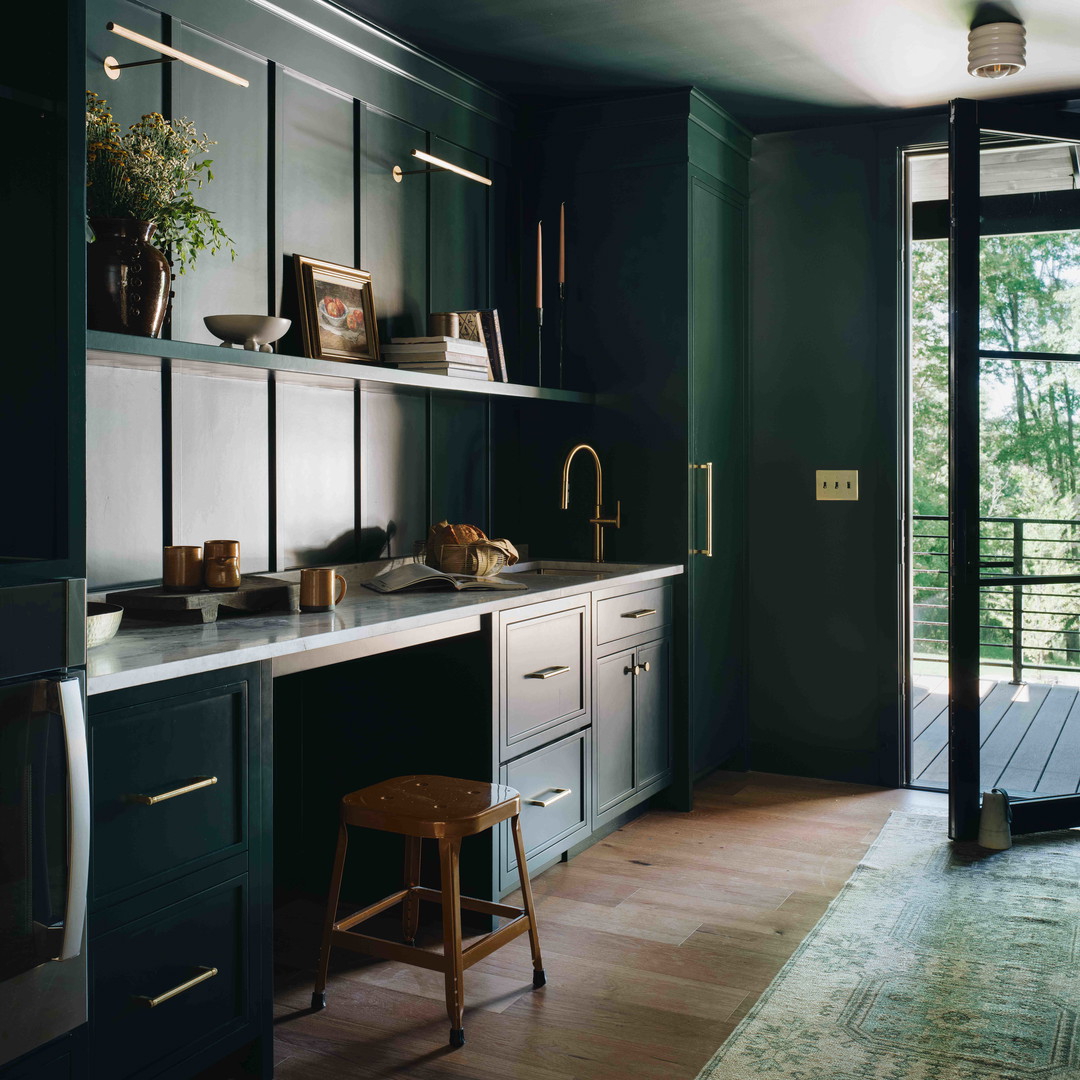 a kitchen with green cabinets and a wooden floor