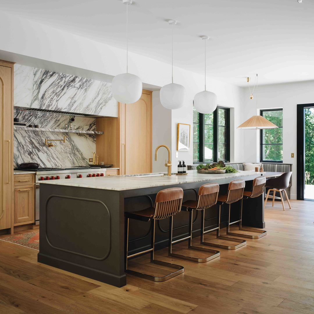 a kitchen with a marble island and wooden floors