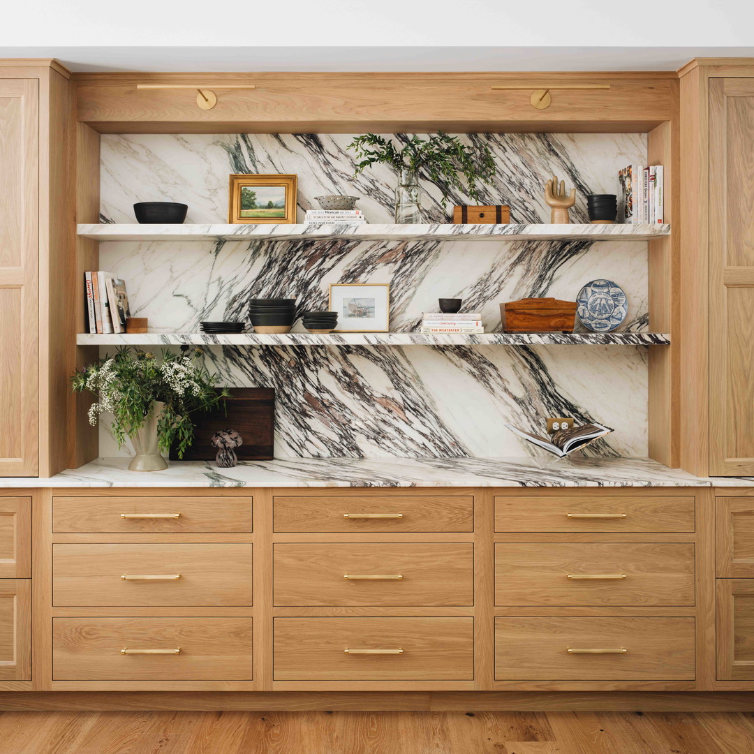 a kitchen with a marble counter top and wooden cabinets