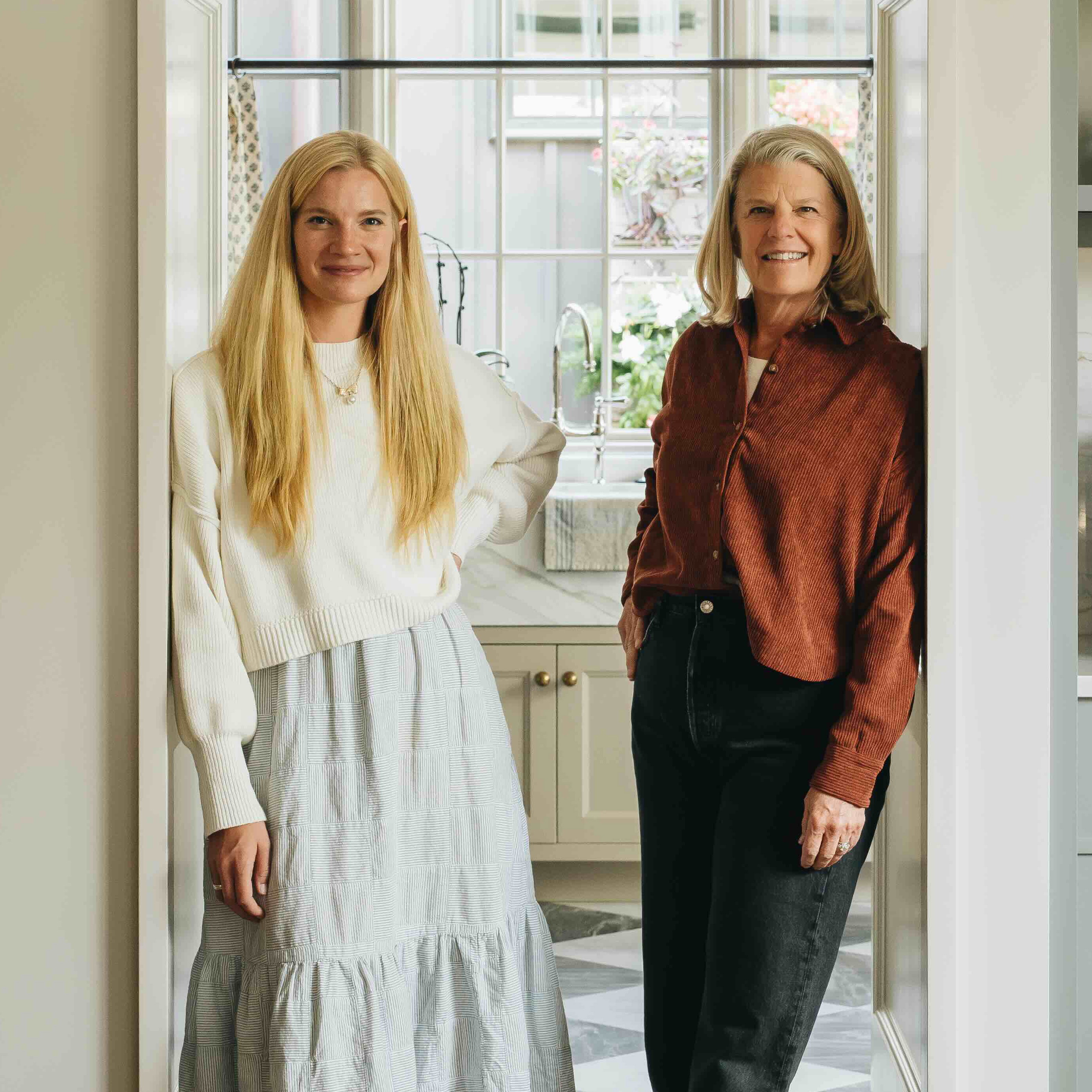 a couple of women standing in a kitchen next to each other