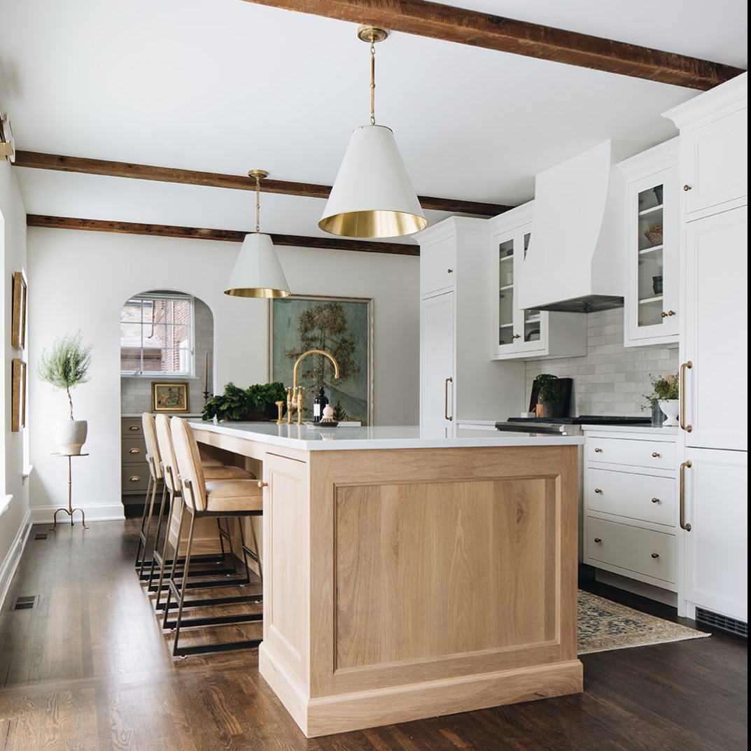 a kitchen with white cabinets and wooden floors