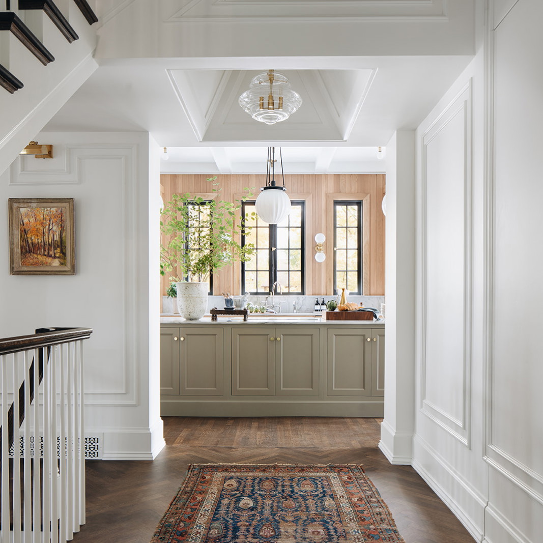 a hallway leading to a kitchen with a rug on the floor