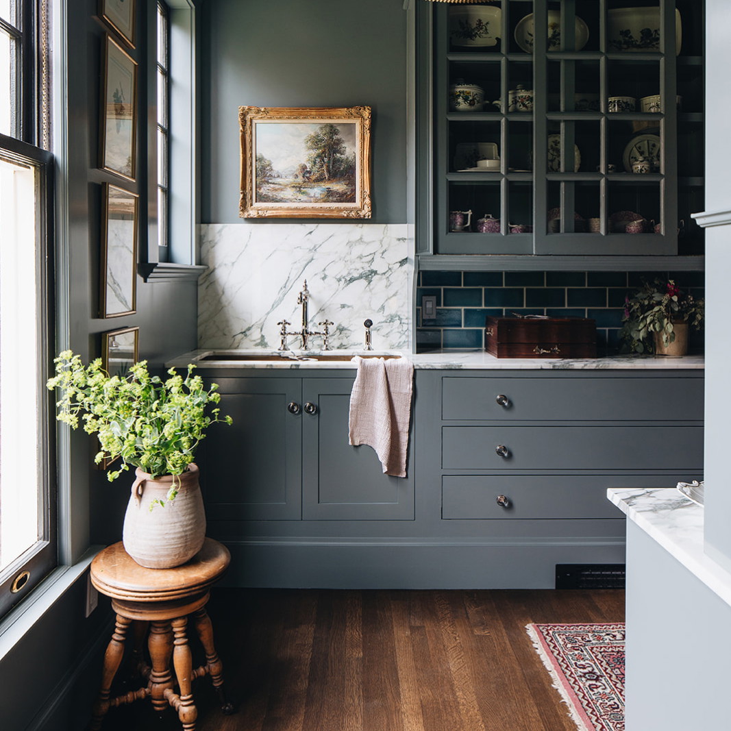 a kitchen with gray cabinets and a white sink