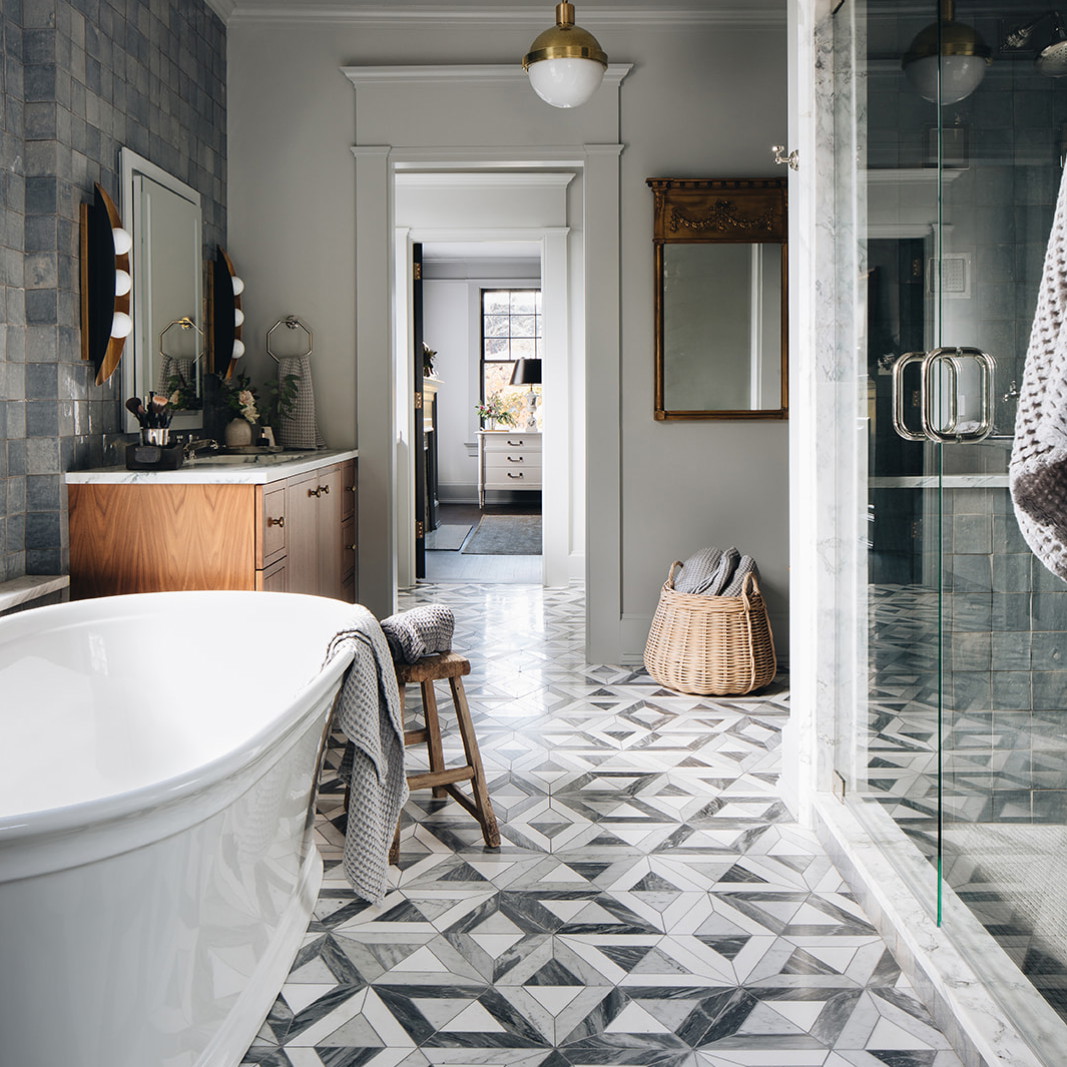 a bath room with a bath tub a mirror and a sink