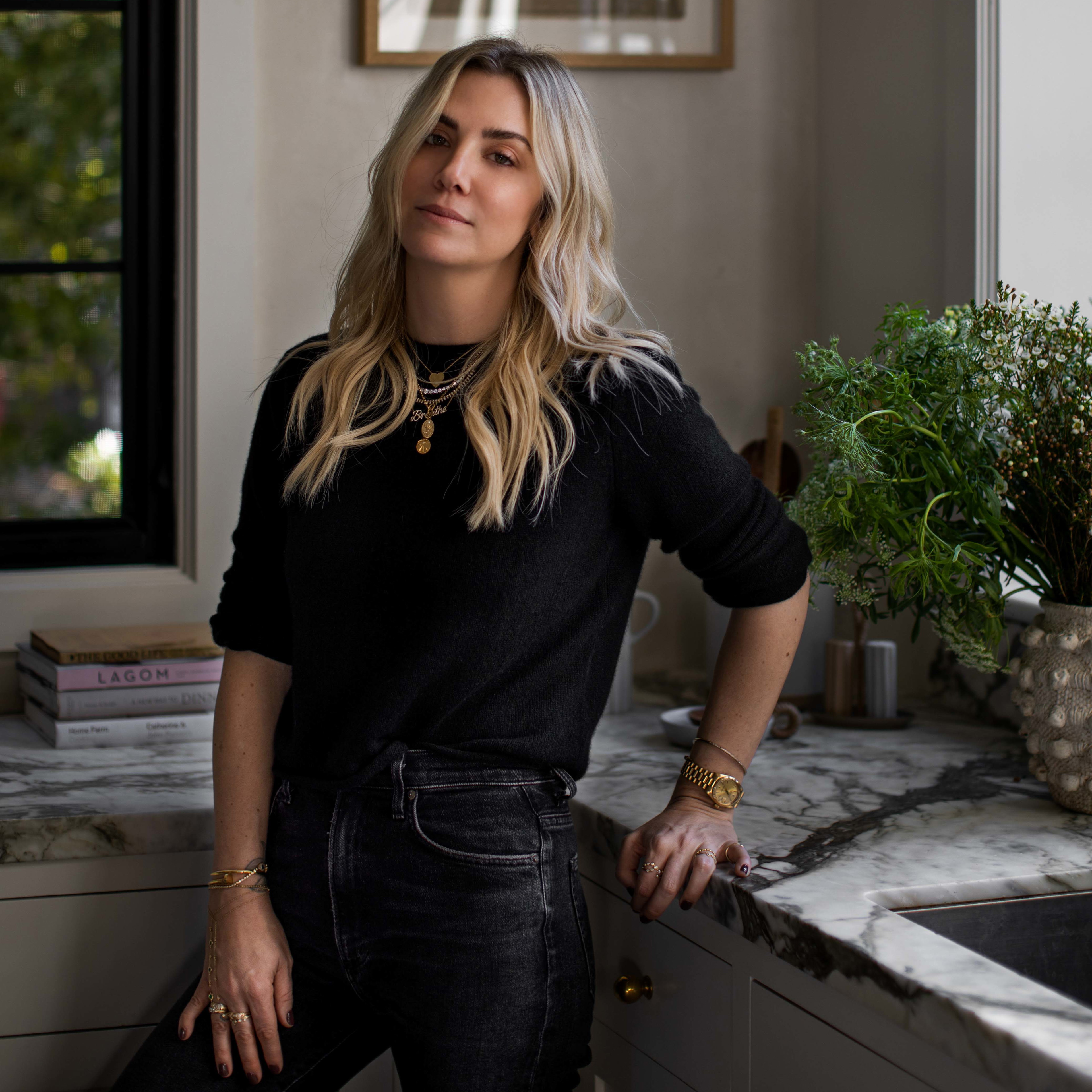 a woman standing in a kitchen next to a window