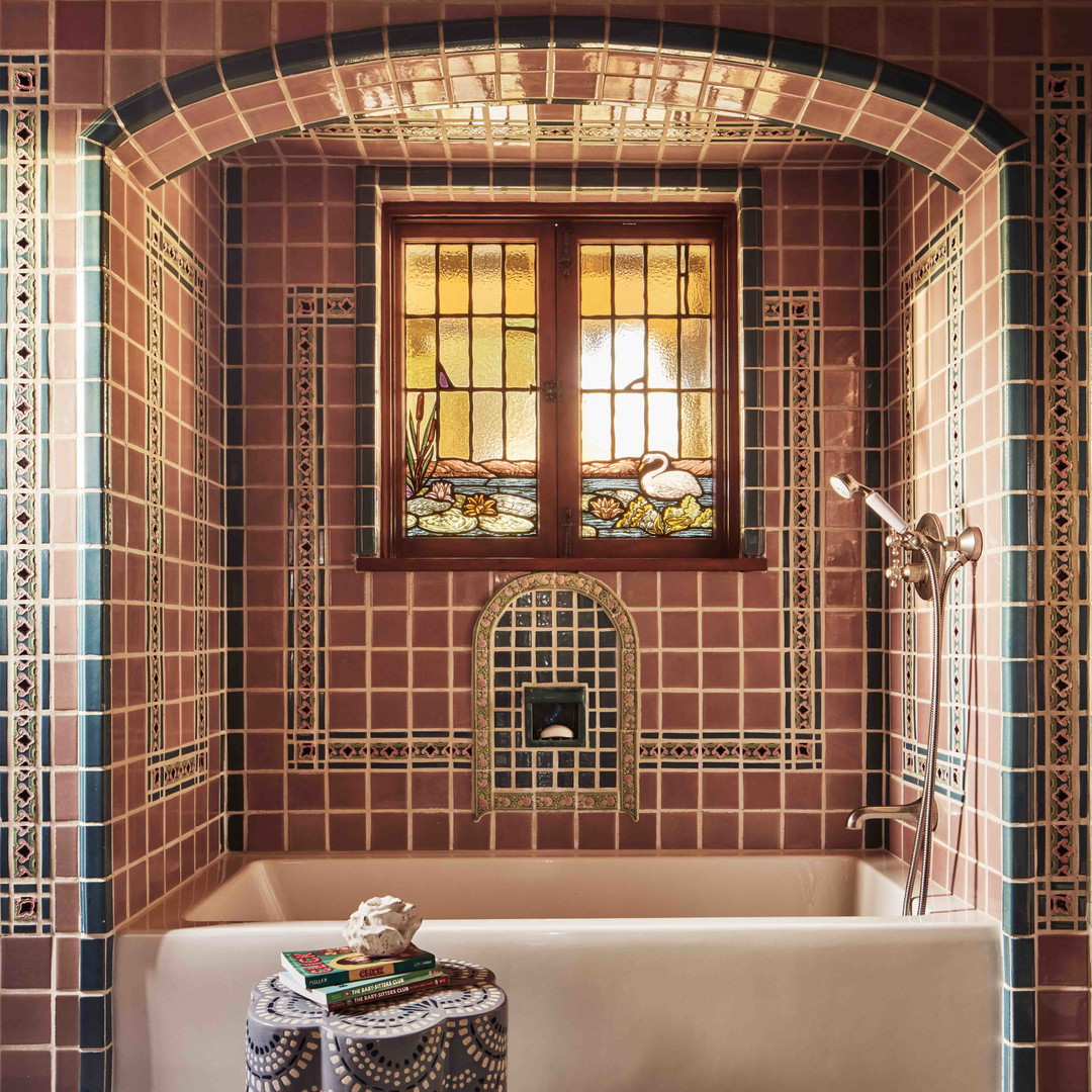 a bath tub sitting under a window in a bathroom