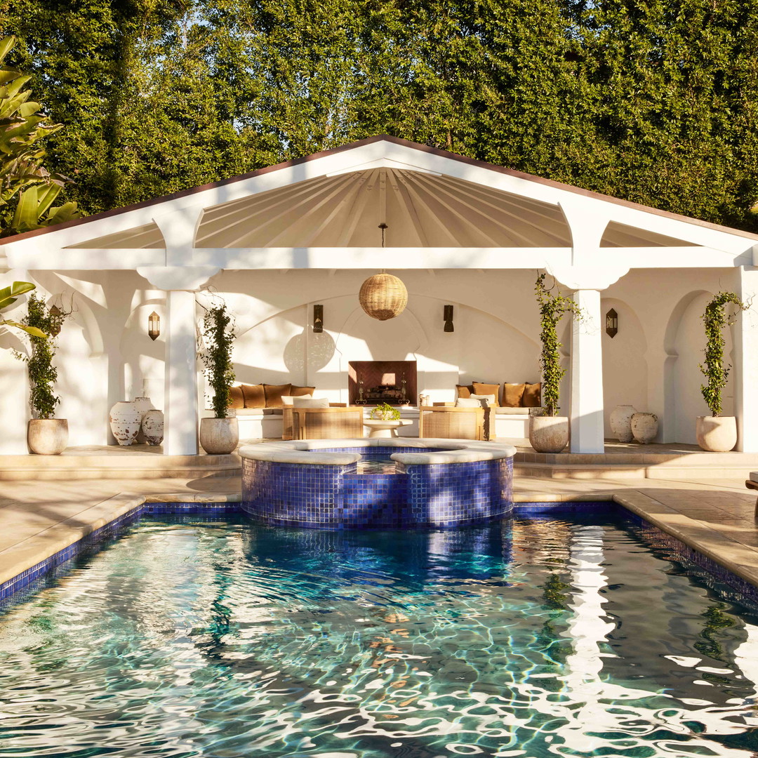 a pool with a gazebo and lounge chairs around it