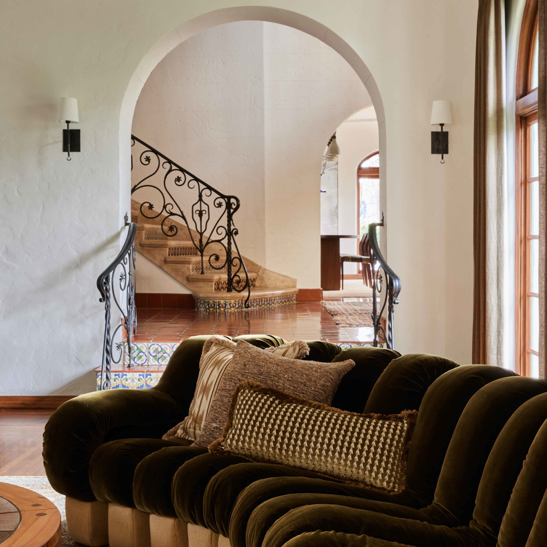 a living room filled with furniture and a spiral staircase